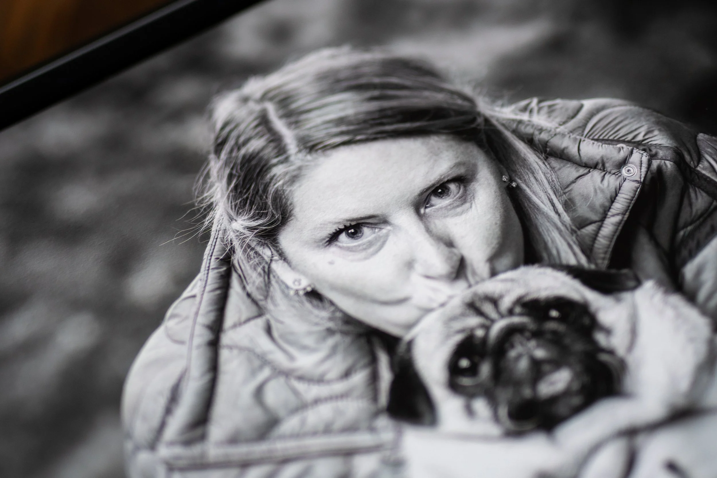 Photo en noir et blanc d'une femme avec un chien, la femme regarde vers la caméra.
