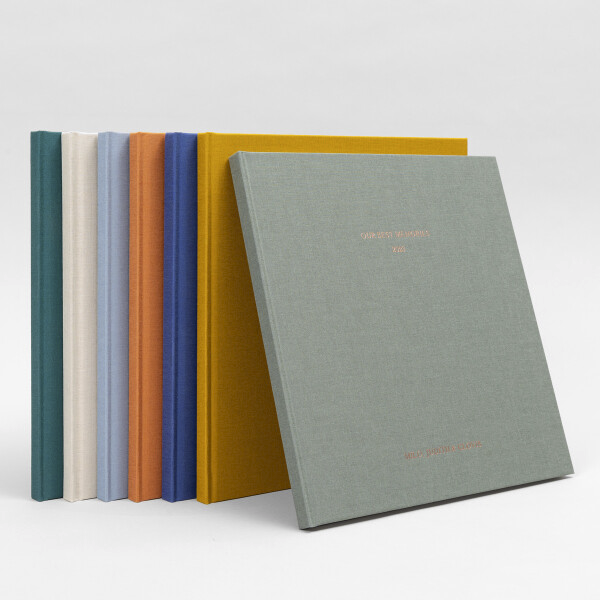 Une collection de livres avec des couvertures colorées alignés sur une surface blanche.