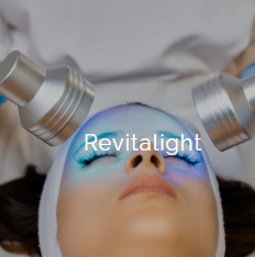 A person undergoing a skincare treatment with two metallic devices on their face, in a clinical or spa setting.