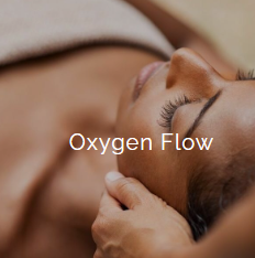 Close-up of a woman receiving oxygen therapy, lying down with eyes closed, and a hand touching her forehead.