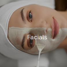 Close-up of a woman's face with a facial mask and a facial treatment applicator on her cheek.