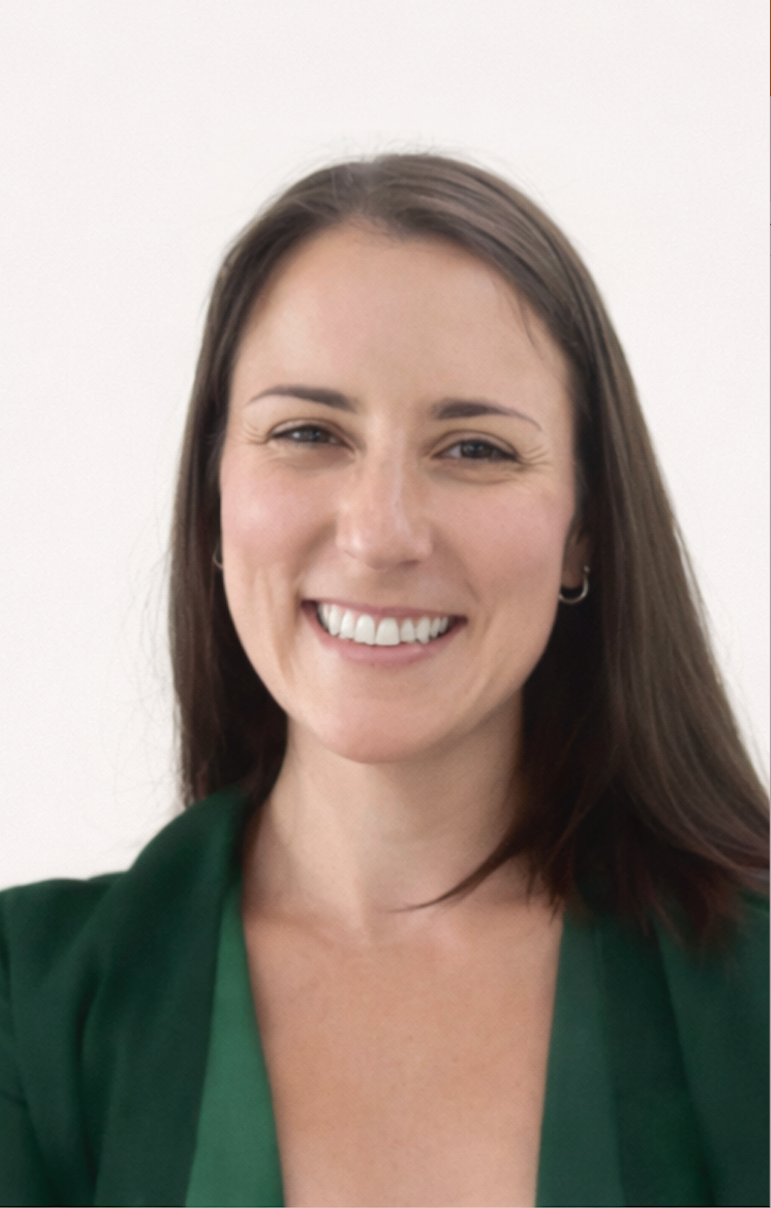 A woman with long brown hair smiling and wearing a green top.