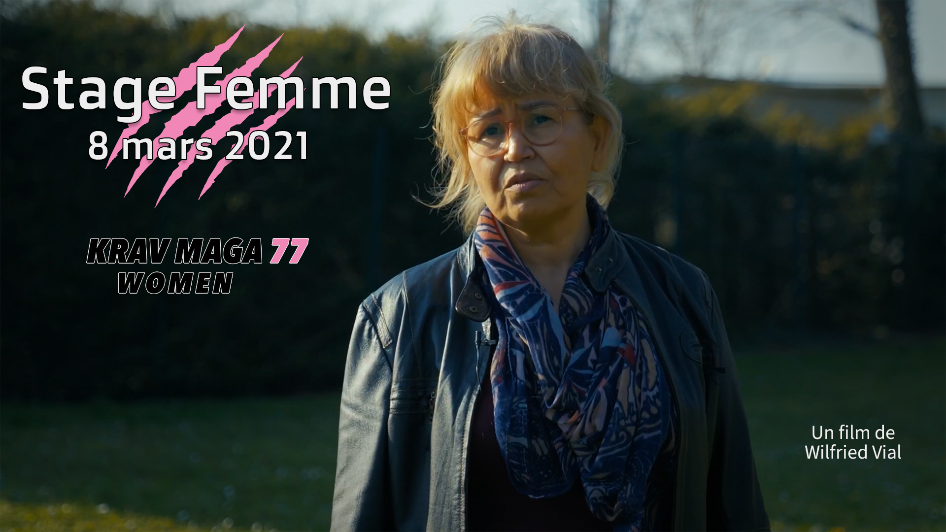 Affiche de la vidéo du Stage Femme de Krav Maga 77. Une femme avec des lunettes, une veste en cuir et un foulard coloré en plein air, le titre de la vidéo sur l'image et la mention "Un film de Wilfried Vial".