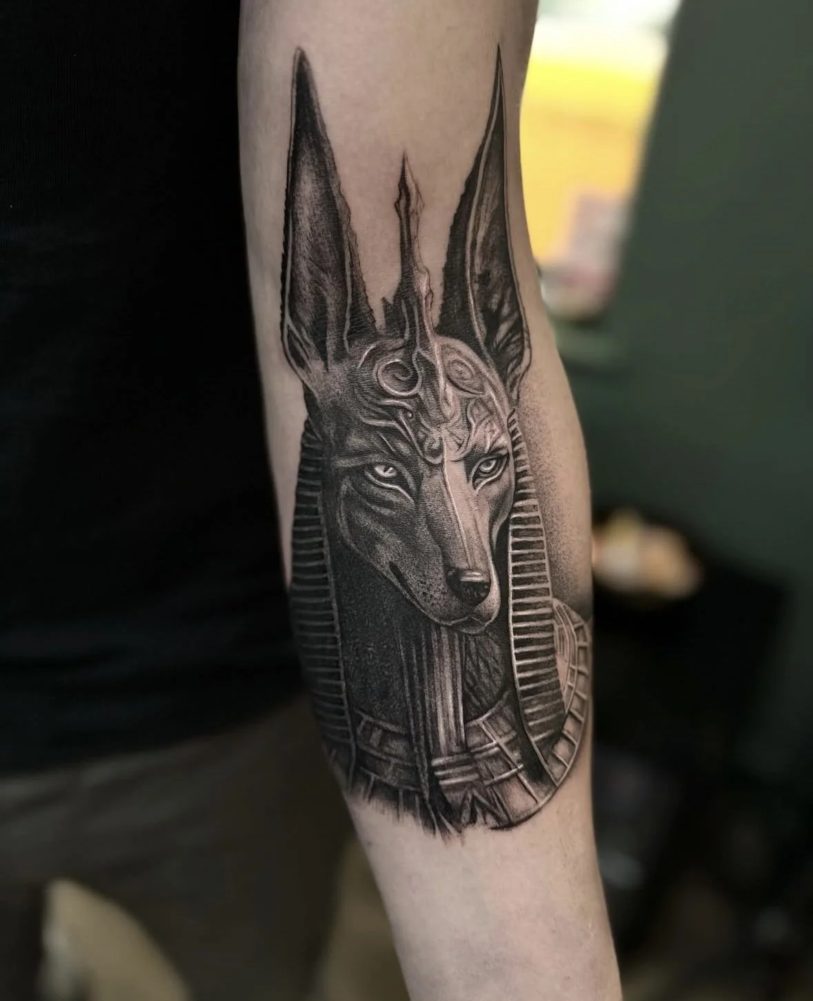 Black and grey tattoo of a wolf with intricate geometric and tribal design elements, covering the person's forearm. Part of a detailed arm tattoo sleeve done in the UK but soon in Sunshine Coast, near Brisbane, Queensland, Australia. 