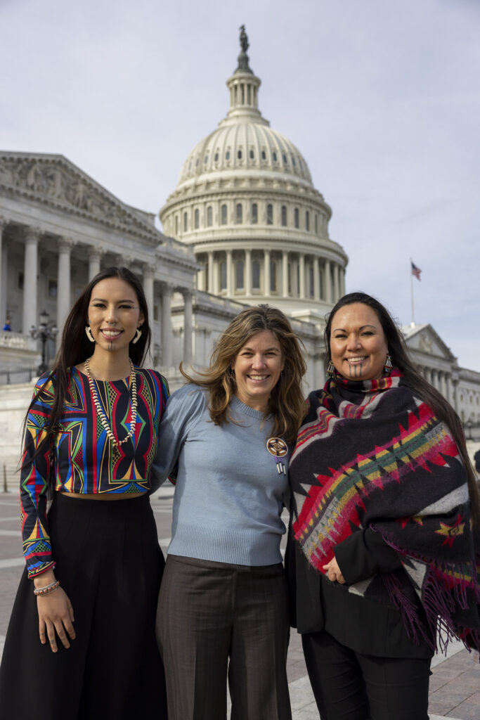 Three women standing in front of the U.S. Capitol building smiling for the camera.