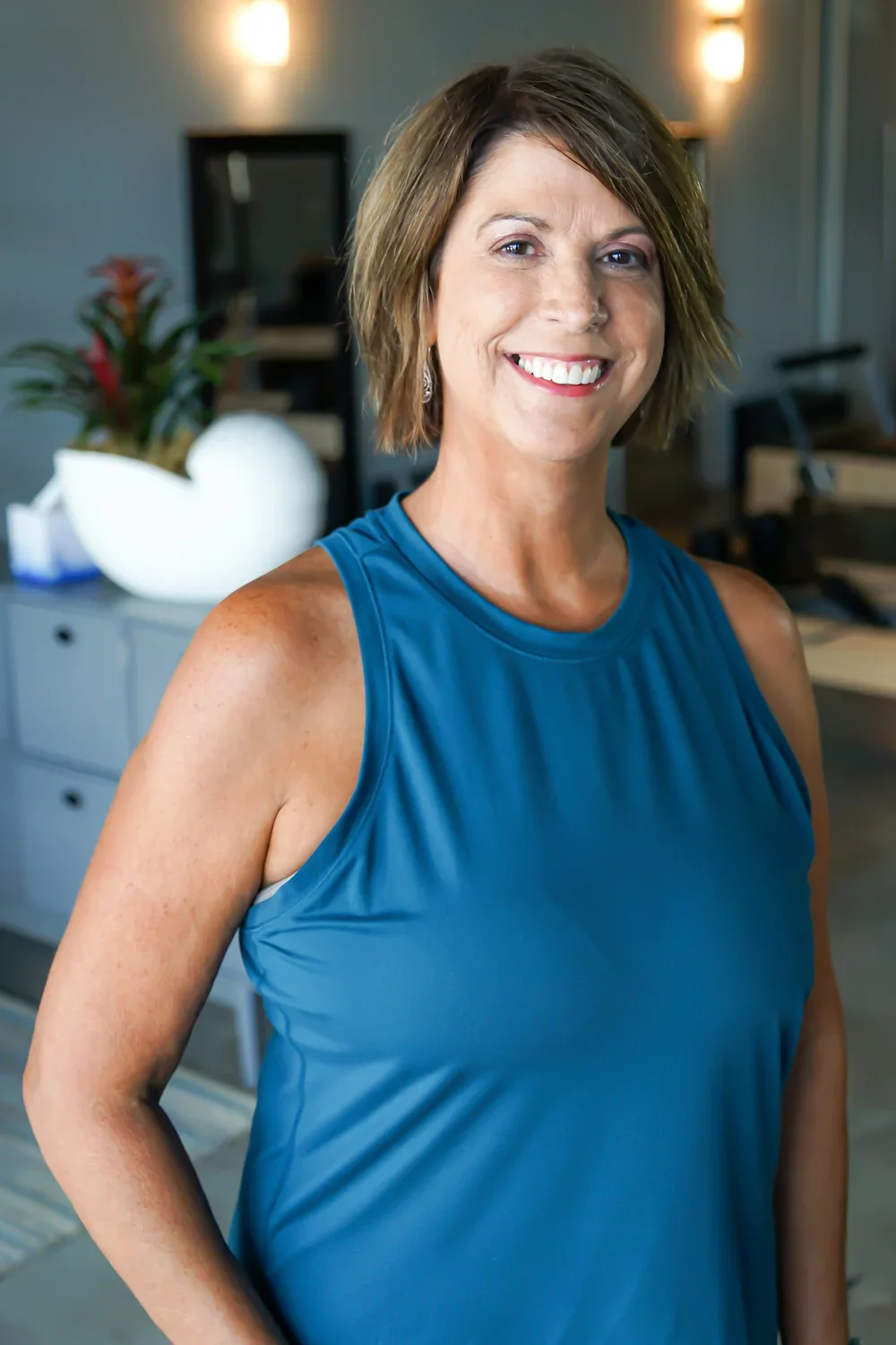Body & Soul Pilates owner Sherry Williams posing in the studio with a blue shirt