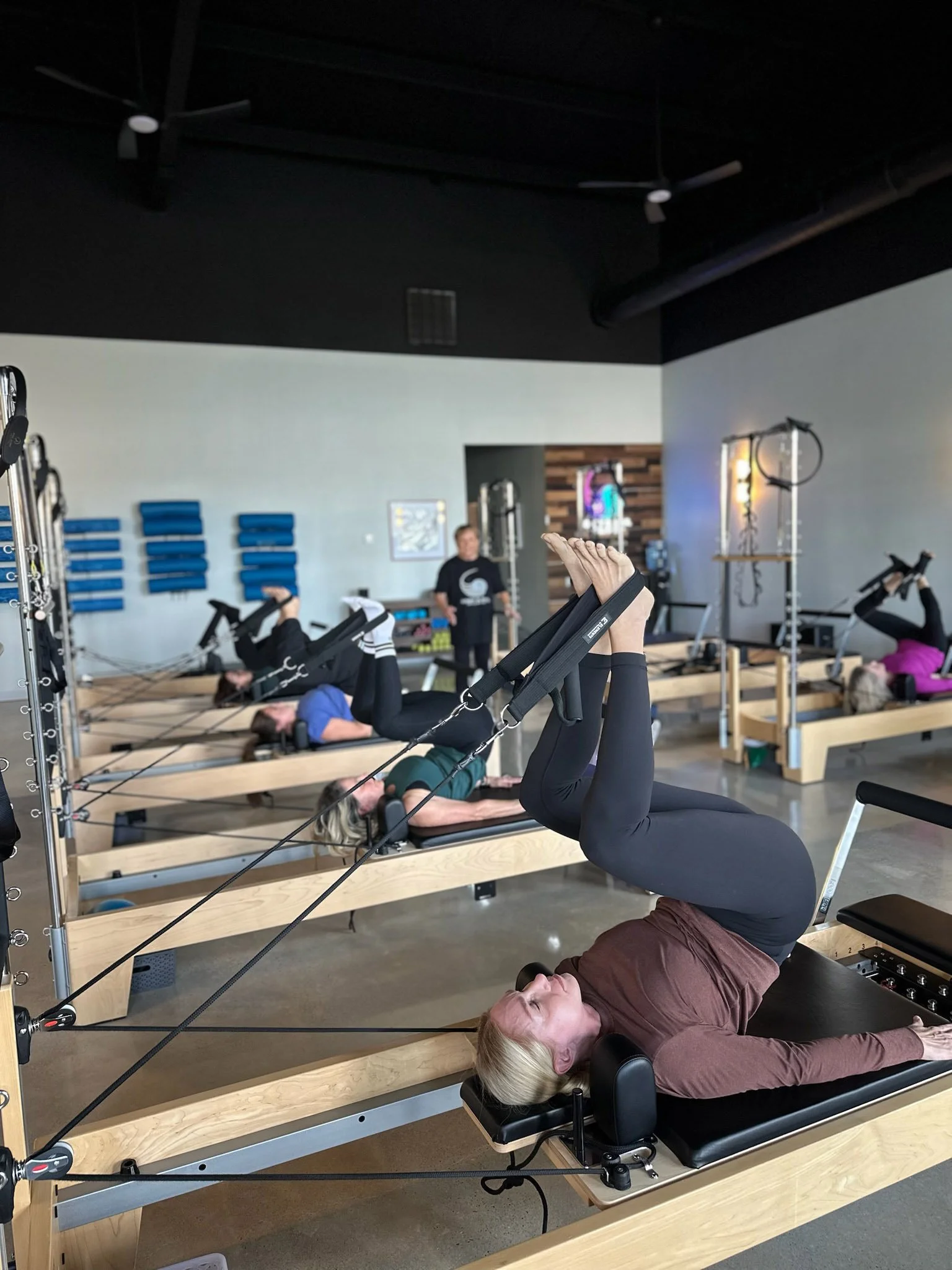 People performing Pilates exercises on reformer machines at Body & Soul Pilates in Gluckstadt, MS
