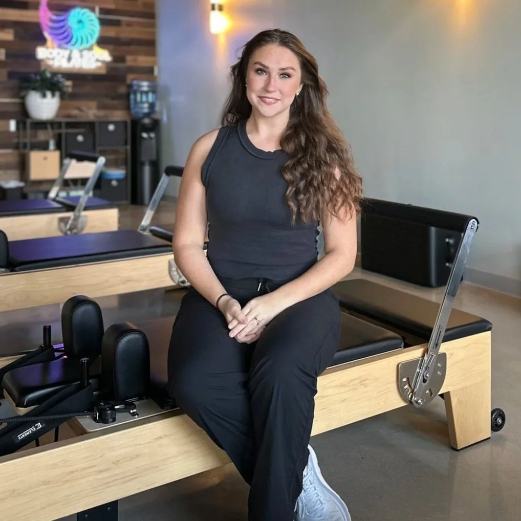 Lilly Bushop, a Gluckstadt, MS Pilates instructor, sitting on a reformer machine at Body & Soul Pilates