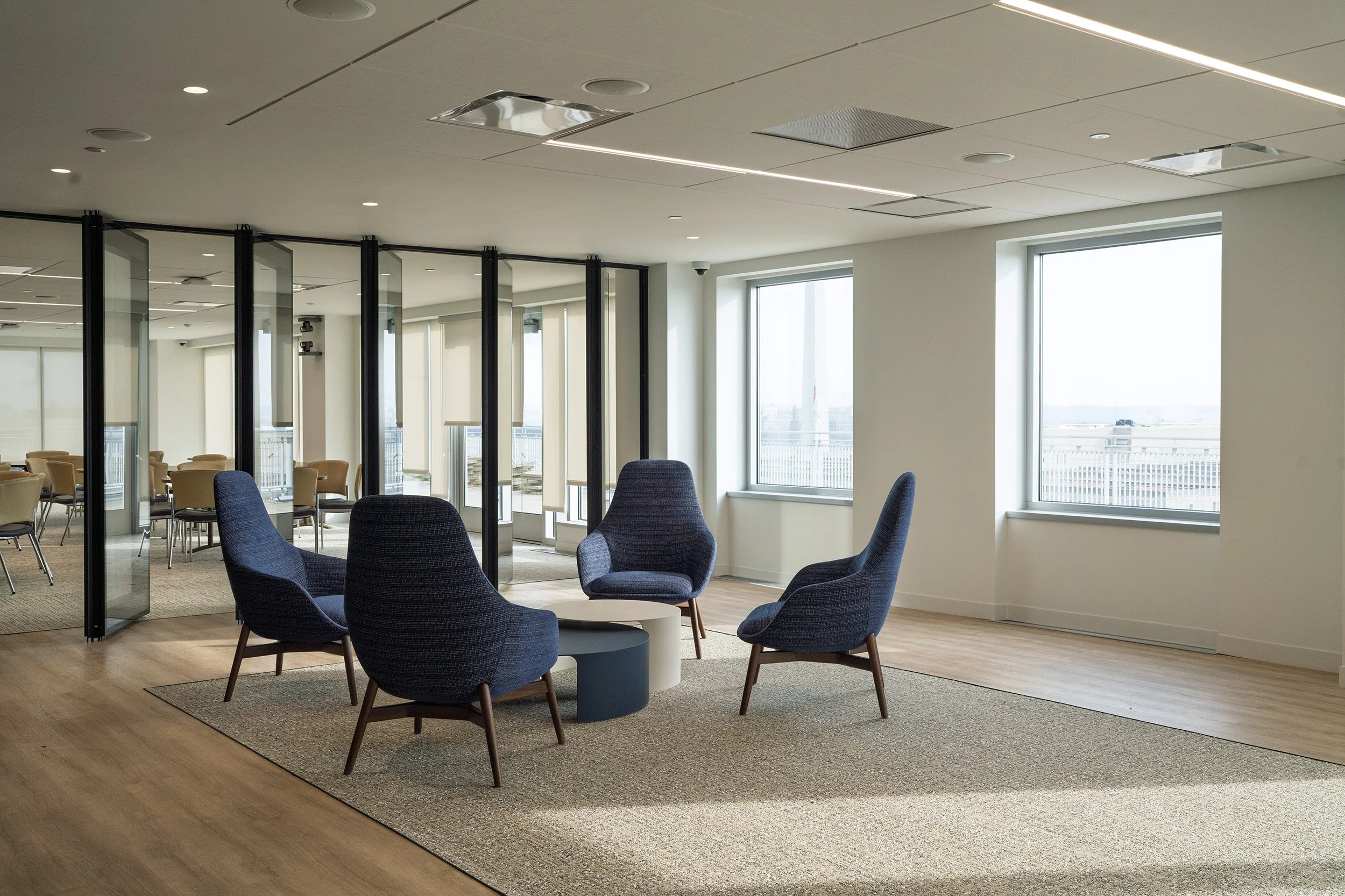 Interior of an office space with folding room dividers, large windows, and modern furniture.