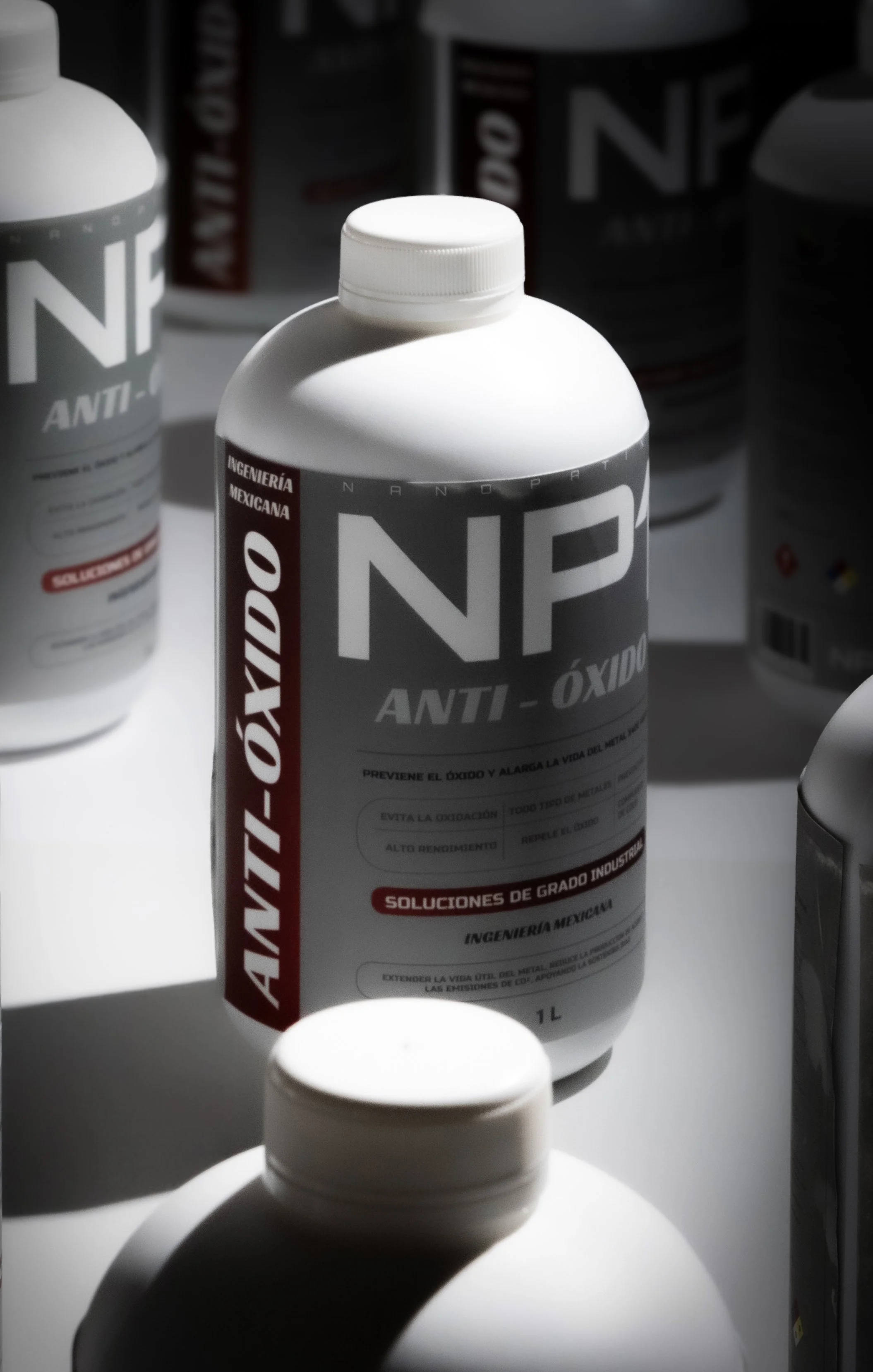 A white plastic bottle labeled 'NP Anti-Oxido' with red and gray accents, standing on a white surface among other similar bottles. The label indicates it is a rust converter chemical, with text in Spanish.