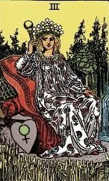 Tarot card depicting The Empress, a woman seated on a throne outdoors, holding a scepter in her right hand, wearing a crown and flowing dress, with a heart symbol on her armrest.