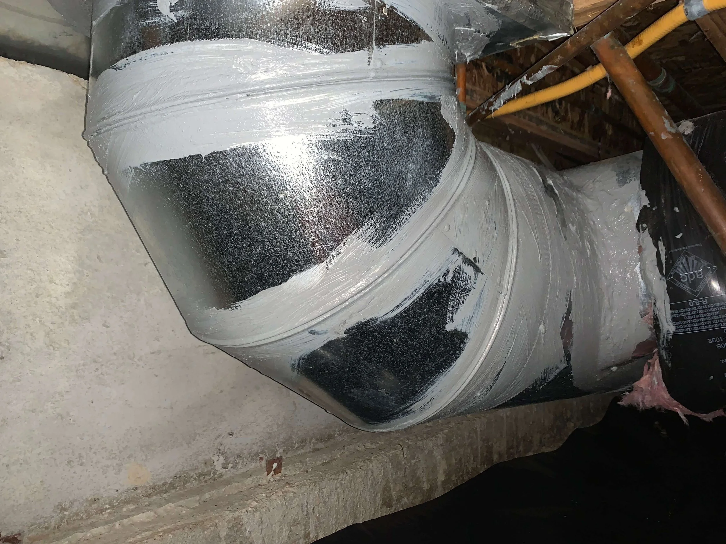 Mastic sealed ductwork in a residential crawl space.