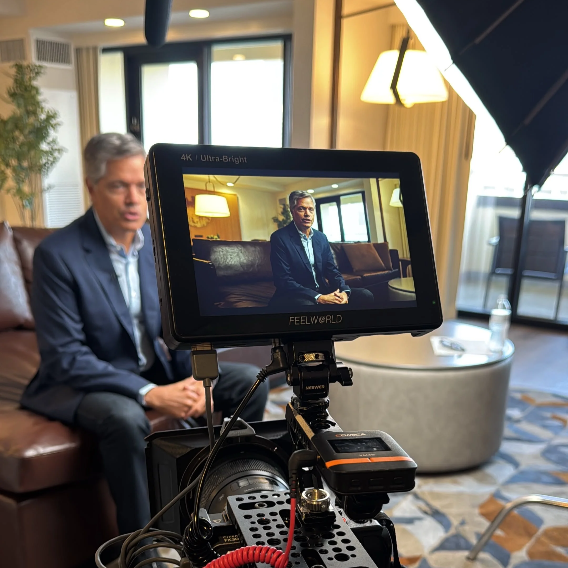 Behind the scenes of a commercial video production with cinema camera, monitor, lighting, and boom microphone