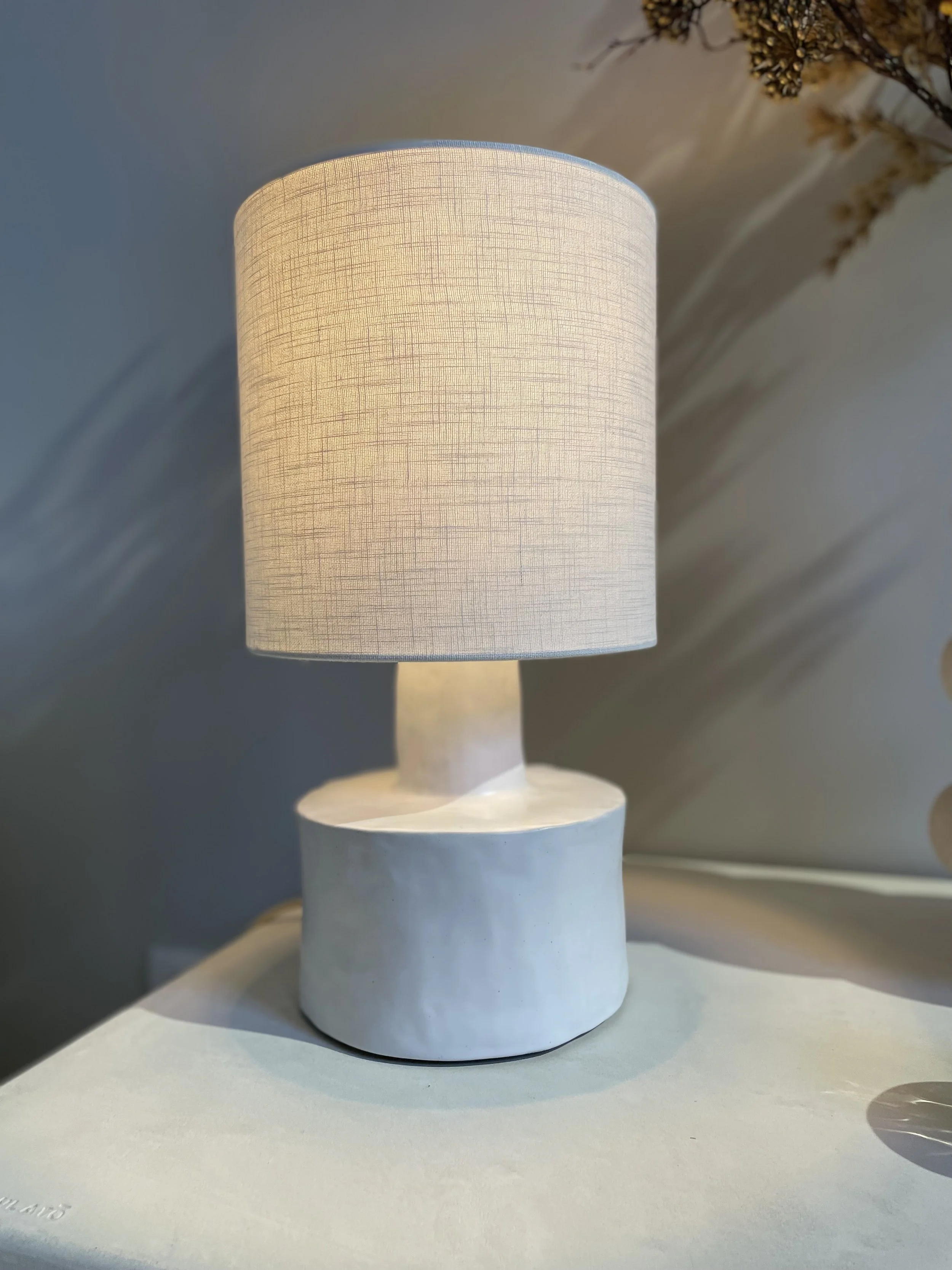 Lampe de table blanche en céramique  avec abat-jour en coton signé SERAX.