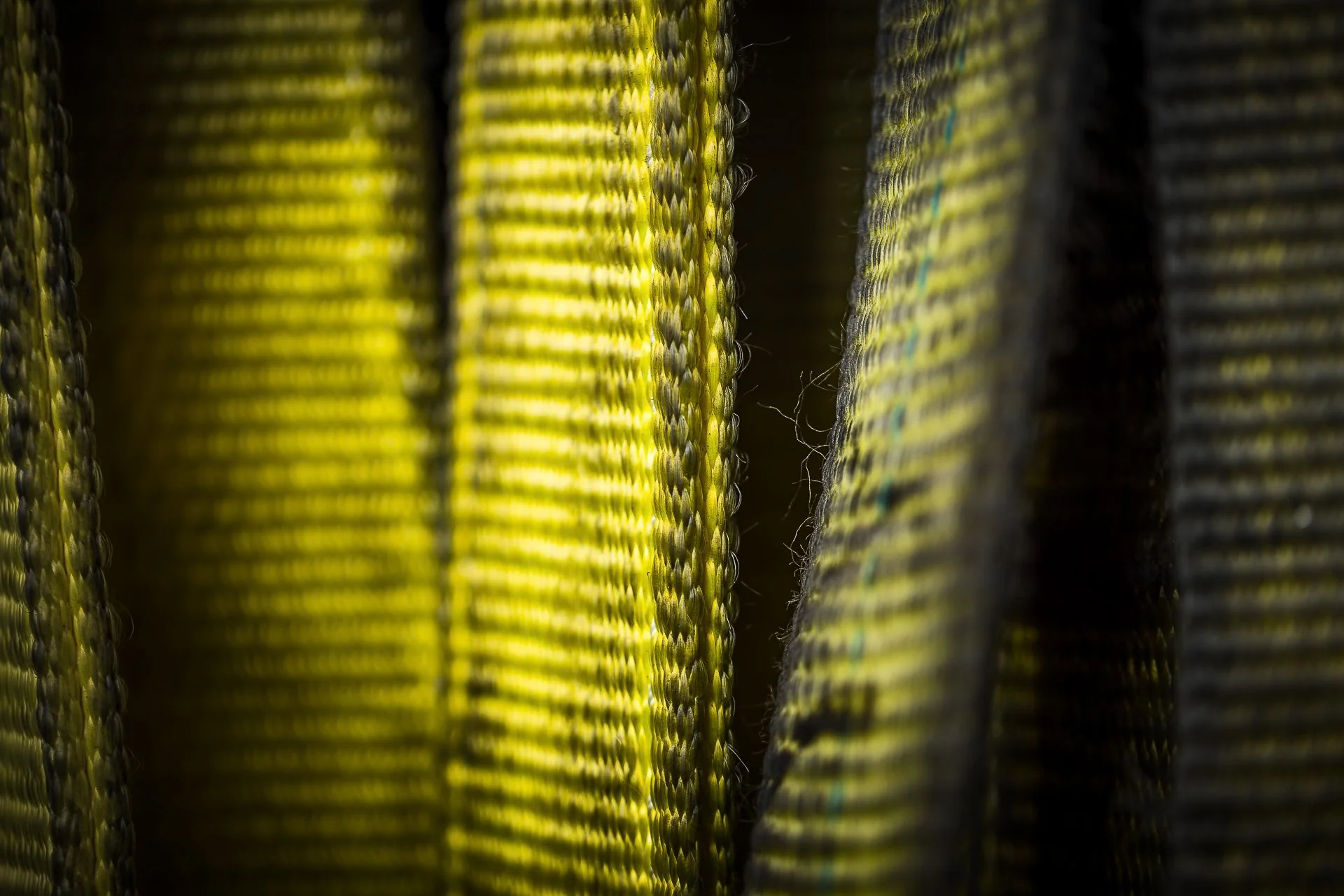 Close-up of a woven textile with yellow, black, and blue threads.