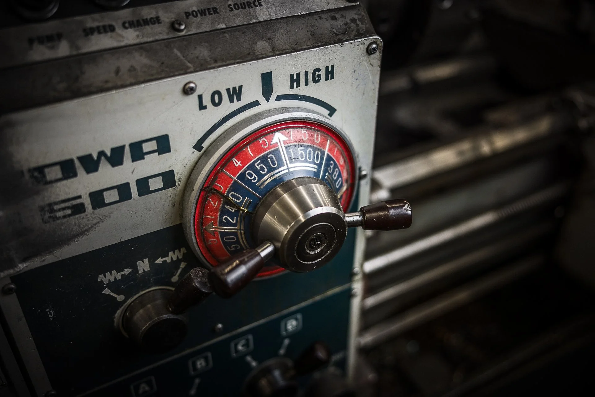 Close-up of a vintage control panel with a large dial, featuring blue and red zones, labeled 'LOW' to 'HIGH', and the words 'WIA 500'. The background shows a blurry metallic surface.