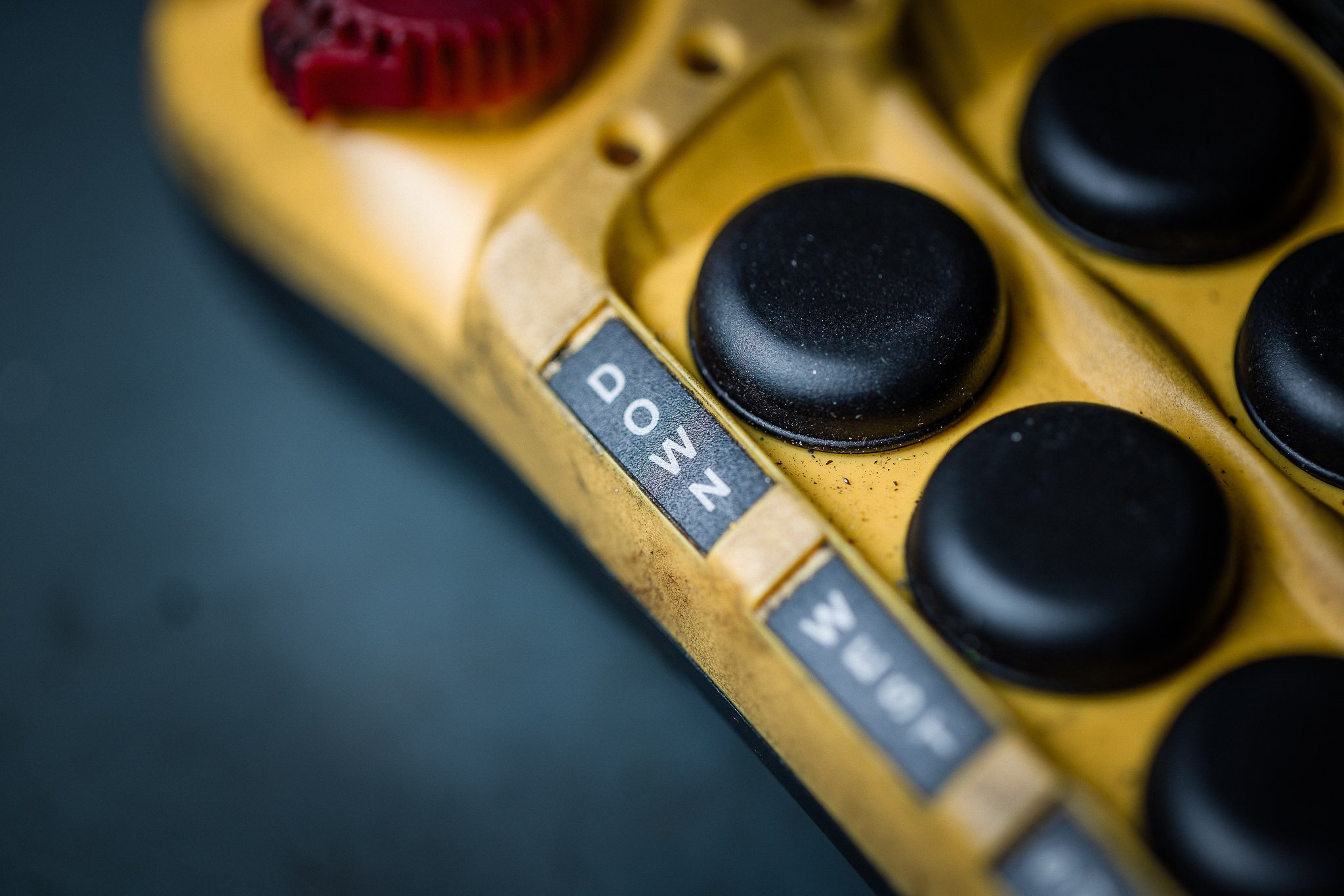 Close-up of yellow electronic device with black buttons, showing labels for 'DOWN' and 'UP'.