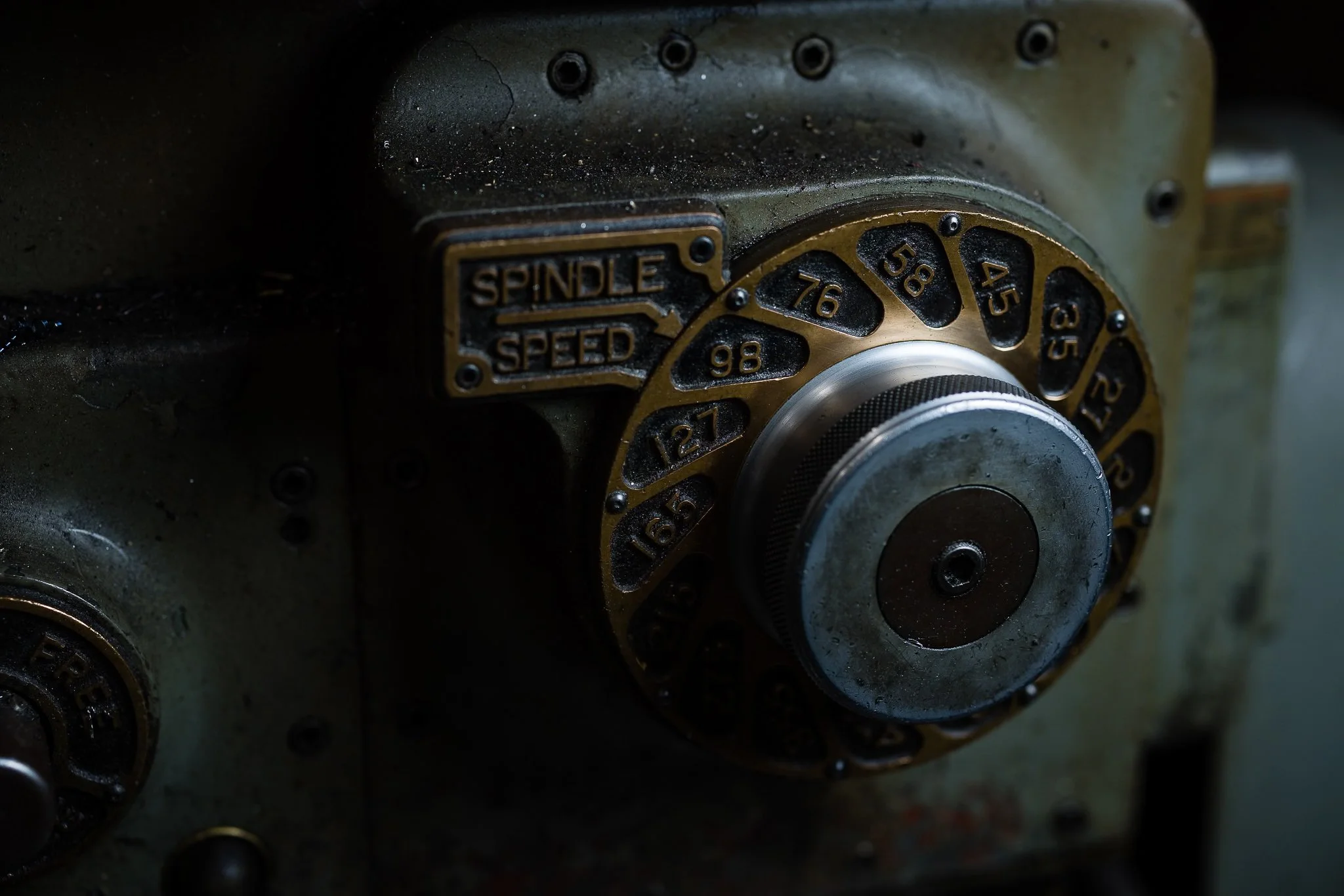 Close-up of an industrial machine dial with numbered settings from 12 to 98, and a label indicating 'SPINDLE SPEED'.