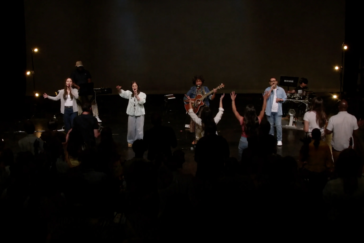 Tammy Iroku and worship team leading live worship during a church service.
