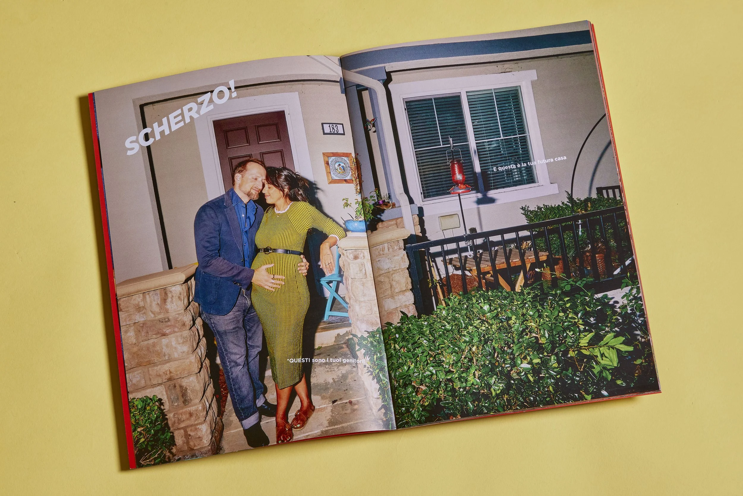 Editorial photography of a family storybook open on an interior spread showing an expecting couple standing outside their home at night, photographed with flash for a family storybook project.