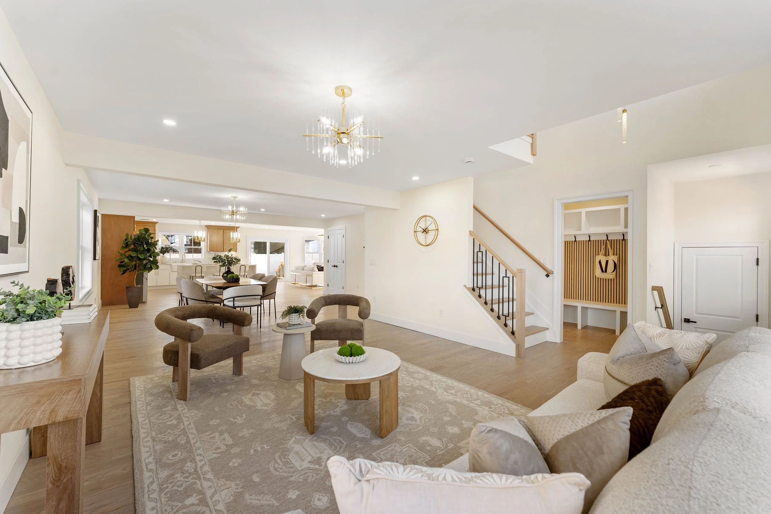 Spacious open-concept living room and dining area with neutral decor, wooden furniture, and modern lighting.