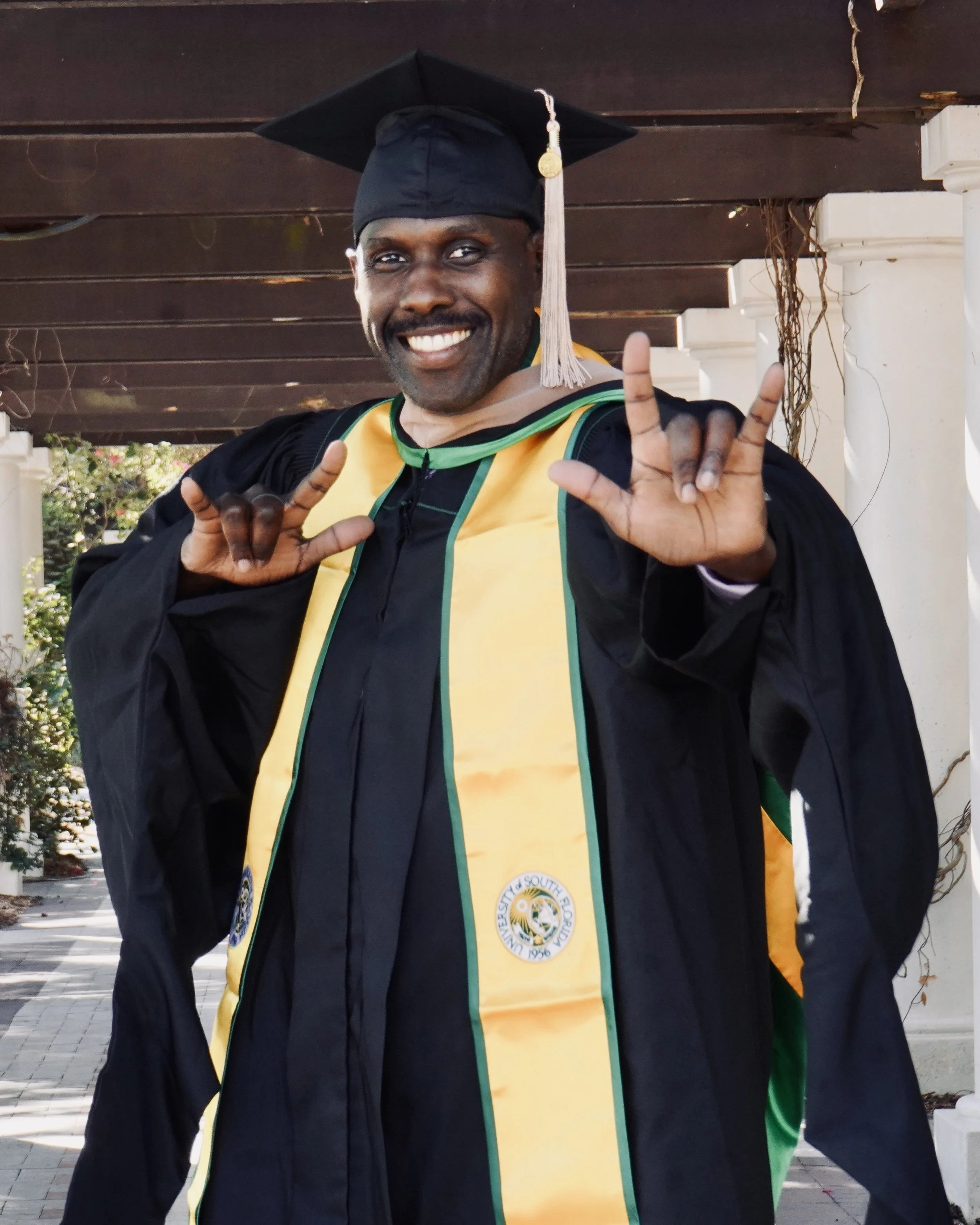 john wearing cap, gown and hood at USF graduation for Master of Business Administration