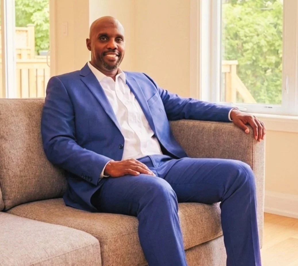 john sitting on couch smiling at camera