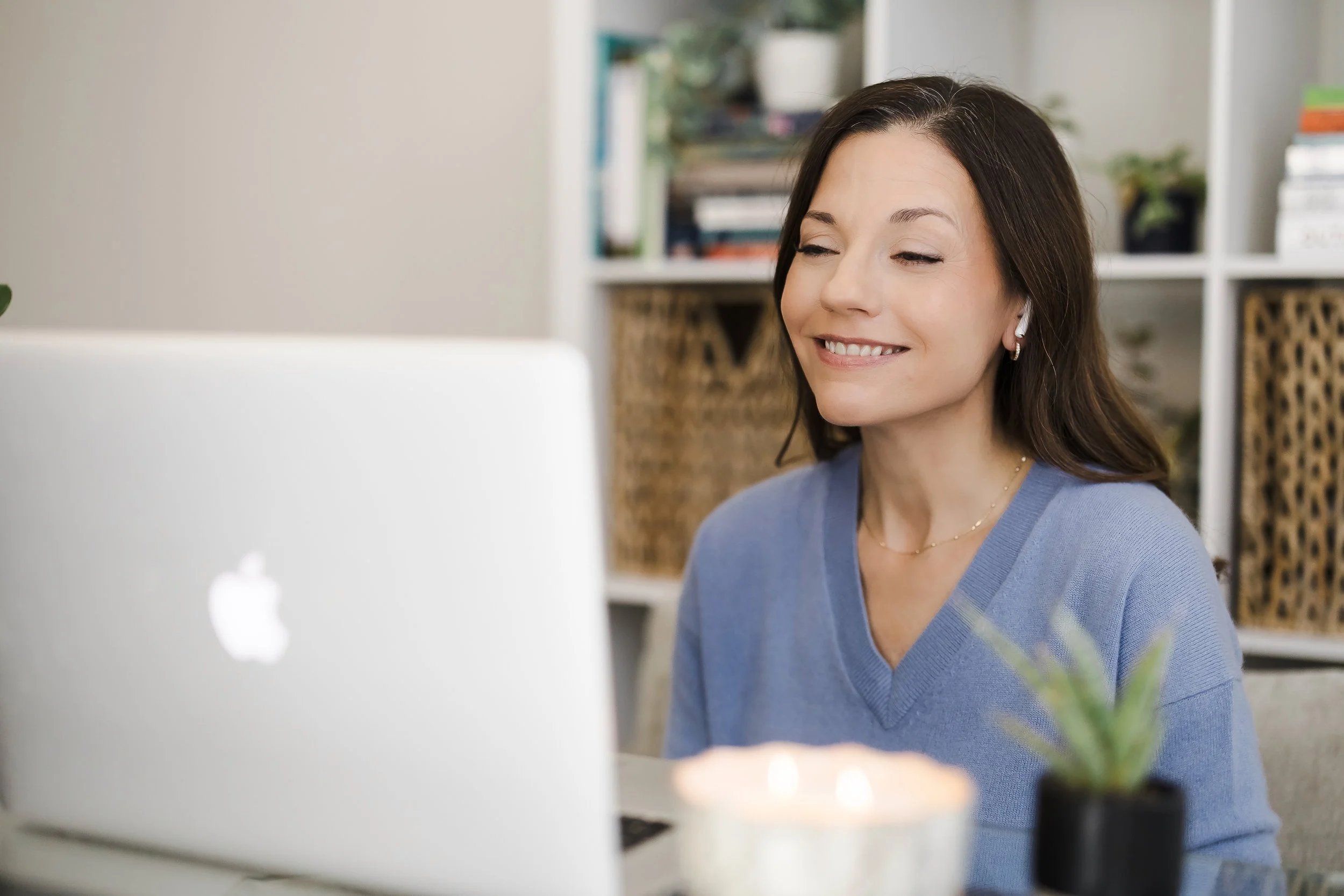 Women smiling with a blue shirt in a therapy office