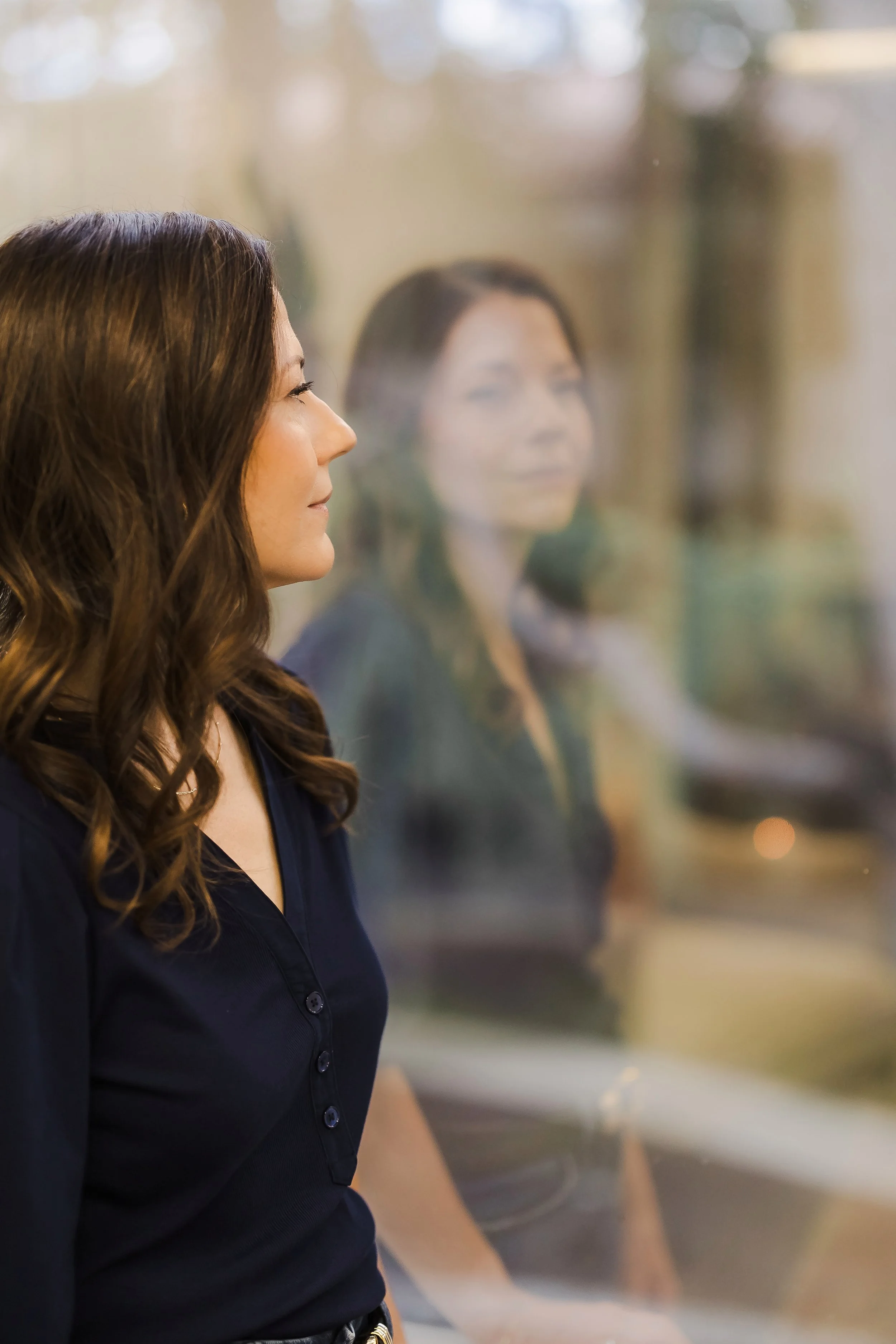 Women looking out at a window pensively