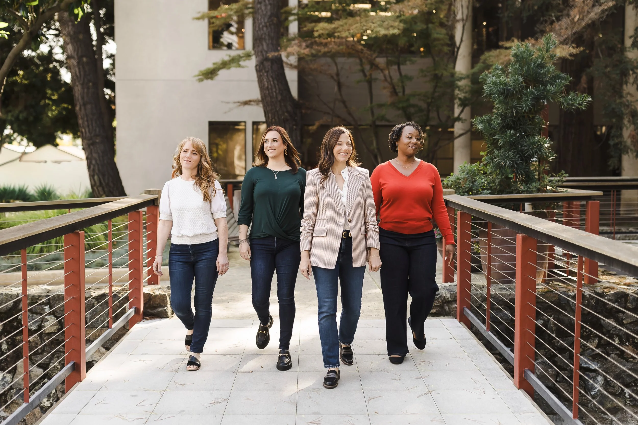 four women walking across the bridge