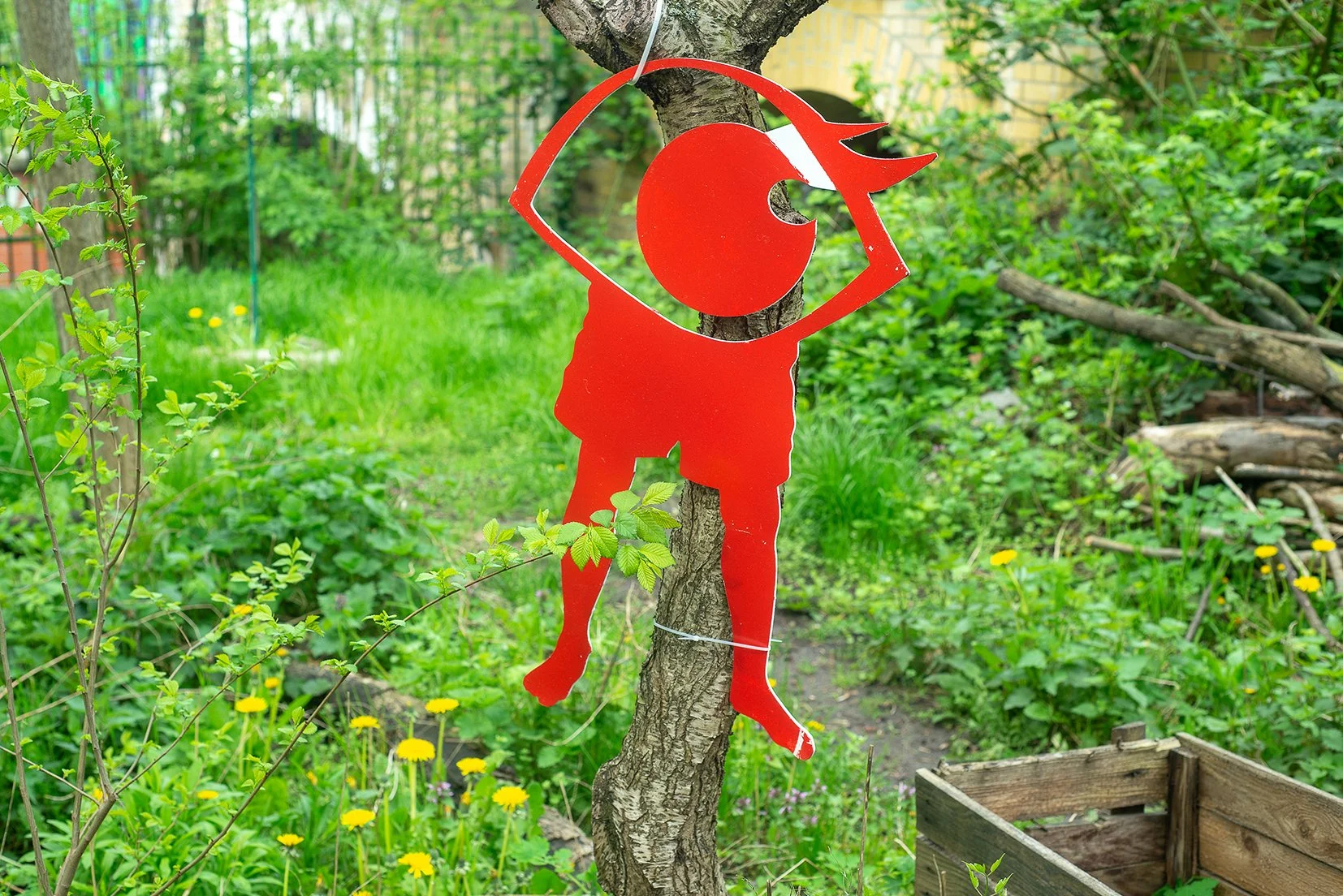 Logo des Festivals hängt als rotes Pappschild an einem Baum