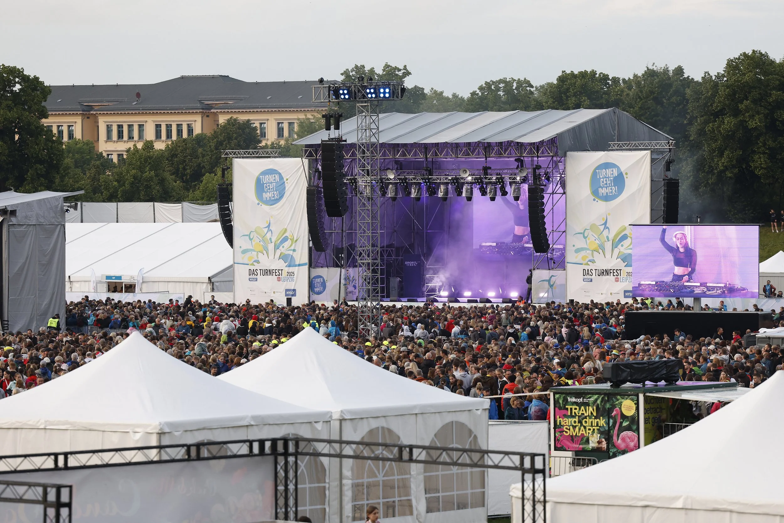 Blick auf Publikum und Bühne während der Eröffnungsfeier auf der Festwiese.