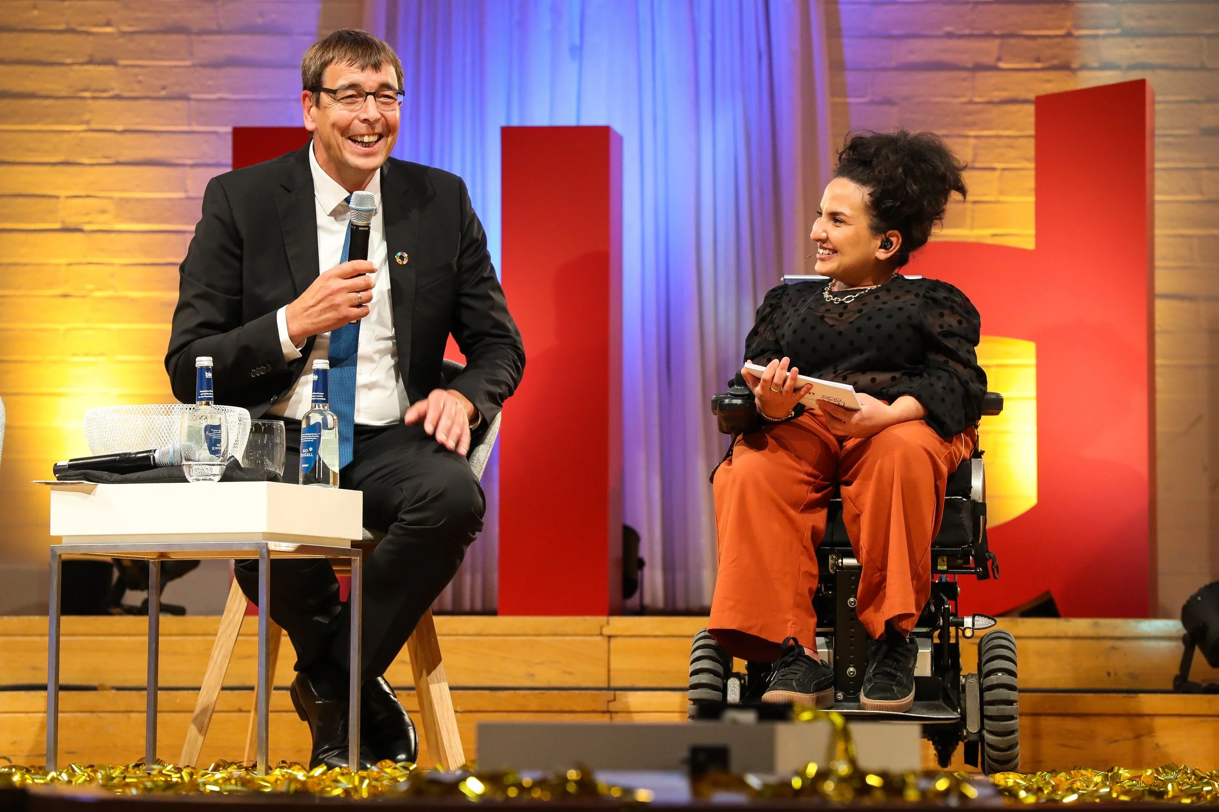 Dr. Stefan Wilhelmy (SKEW) und Moderatorin Kübra Sekin auf der Bühne.