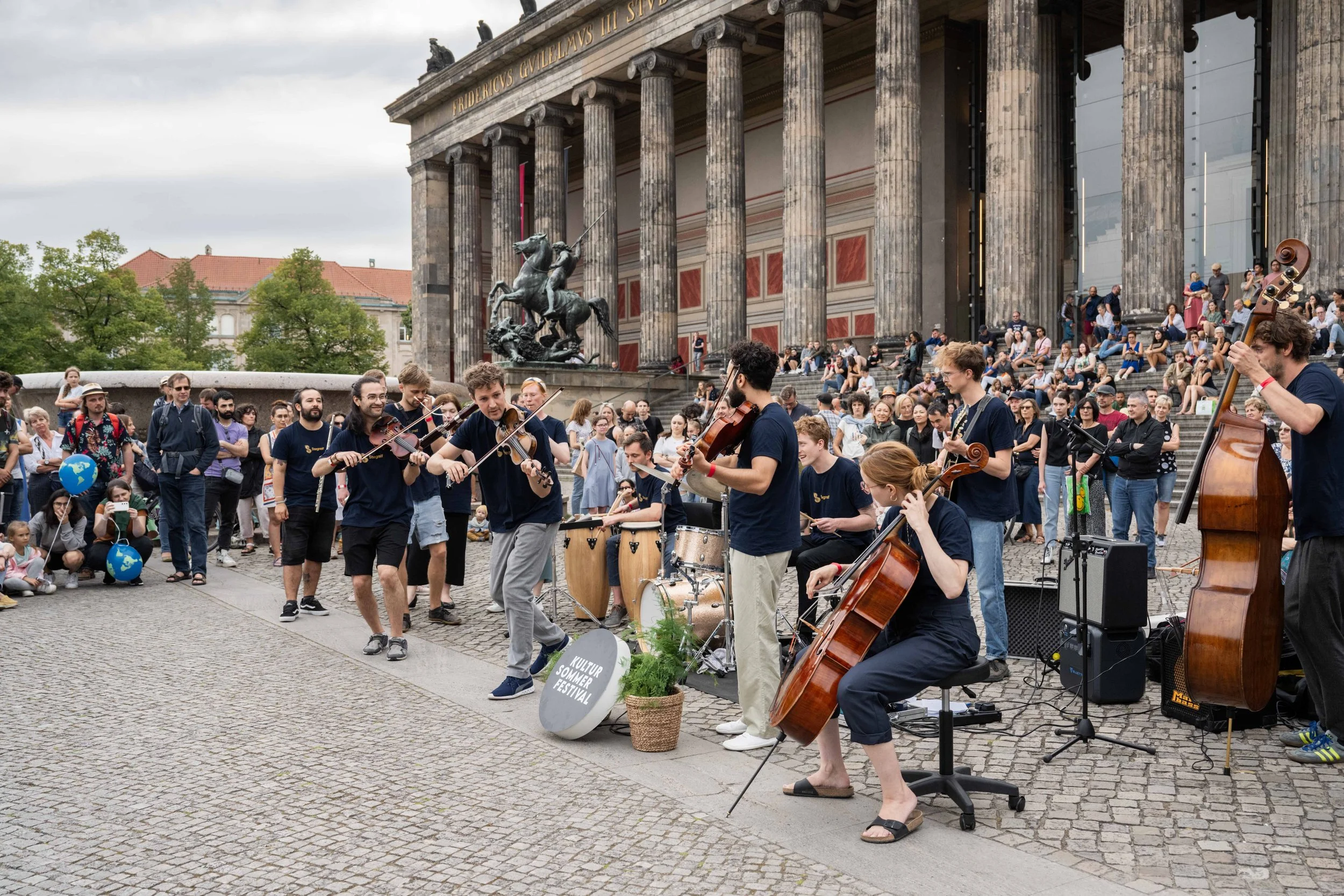 Ein Ensemble aus Streichern und Percussion spielt vor dem Alten Museum.