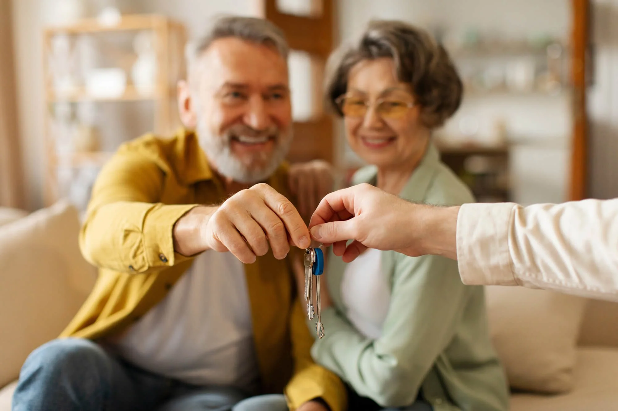 A senior couple receives the keys to a new home with guidance from a senior real estate consultant.