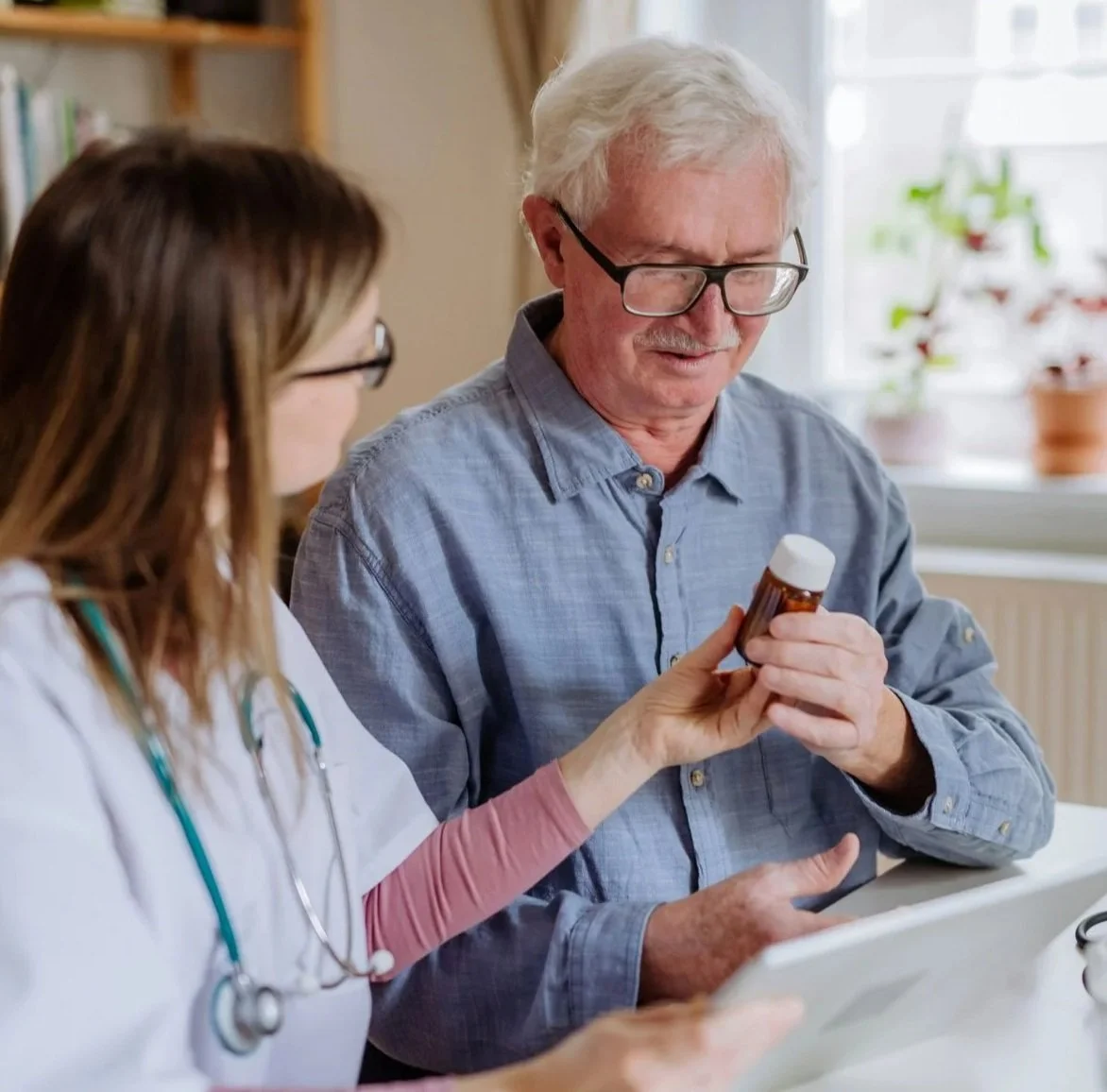 A caregiver provides senior medication help by assisting an older adult with their daily medications.