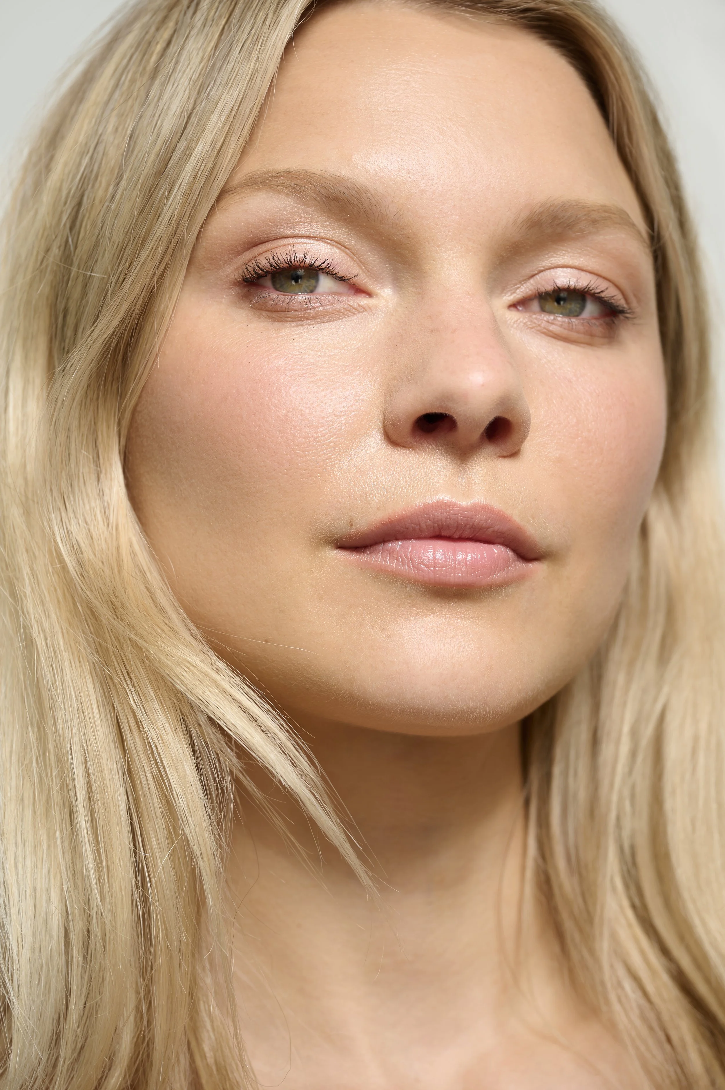 Close-up portrait of a woman with blonde hair, fair skin, and subtle makeup.