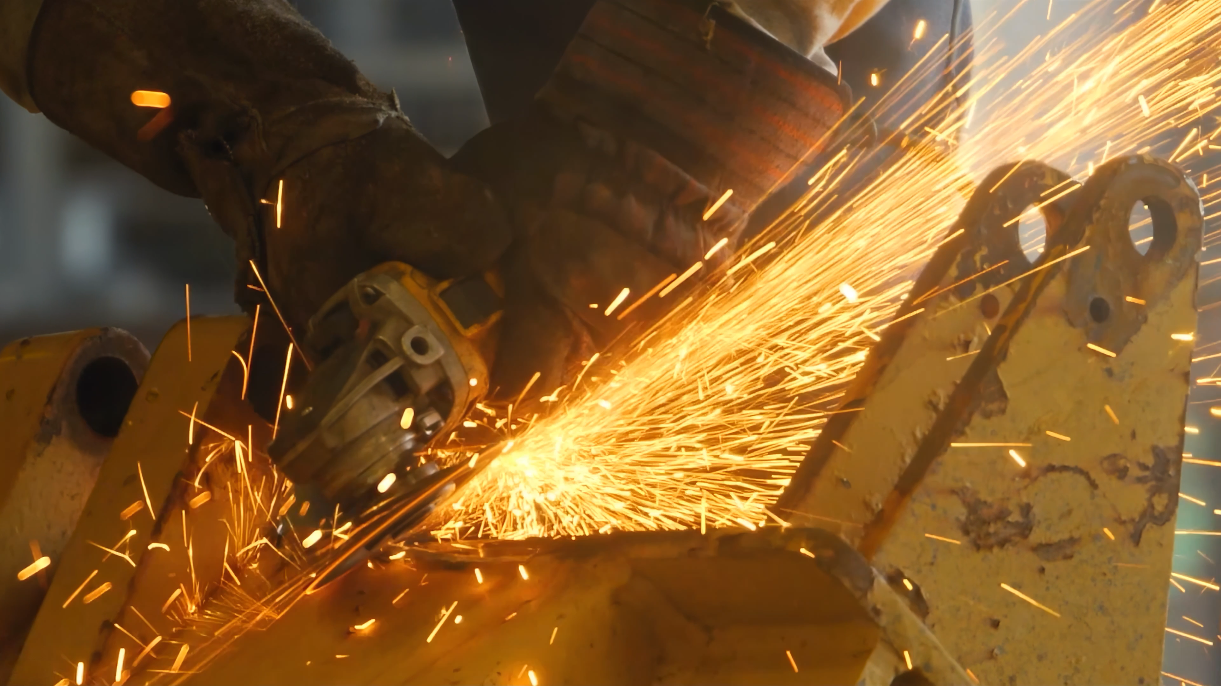 A worker welding metal parts with sparks flying in the workshop.