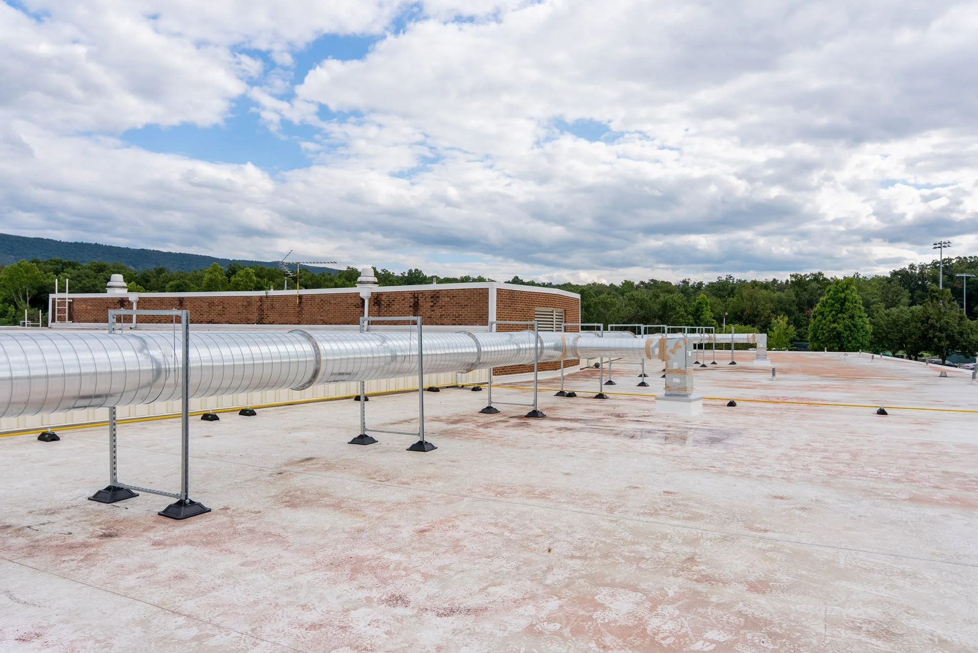 Newly fabricated commercial HVAC ductwork resting on rooftop supports at Sandy Hook Elementary School in Strasburg, Virginia.