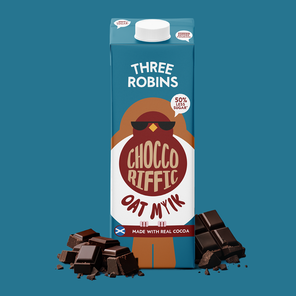 A carton of Three Robins Chocco Riffic Oat Milk, made with real cocoa, with pieces of chocolate in front of it on a blue background.