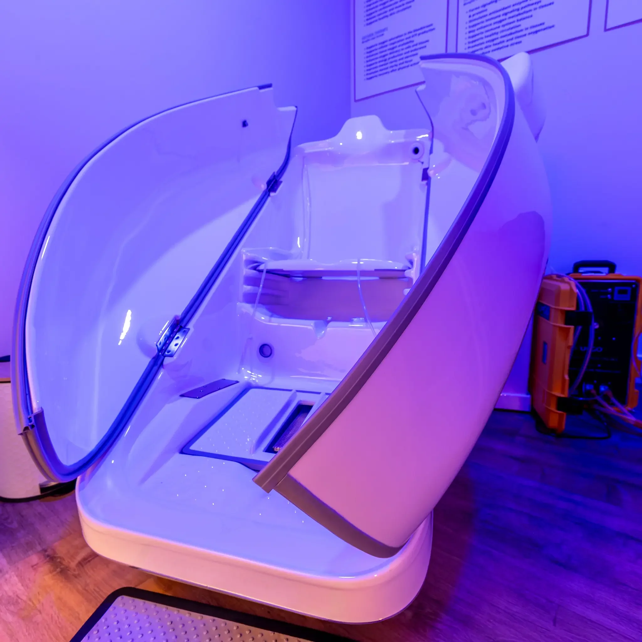 MRI machine with a patient inside, illuminated with purple light, in a medical setting.