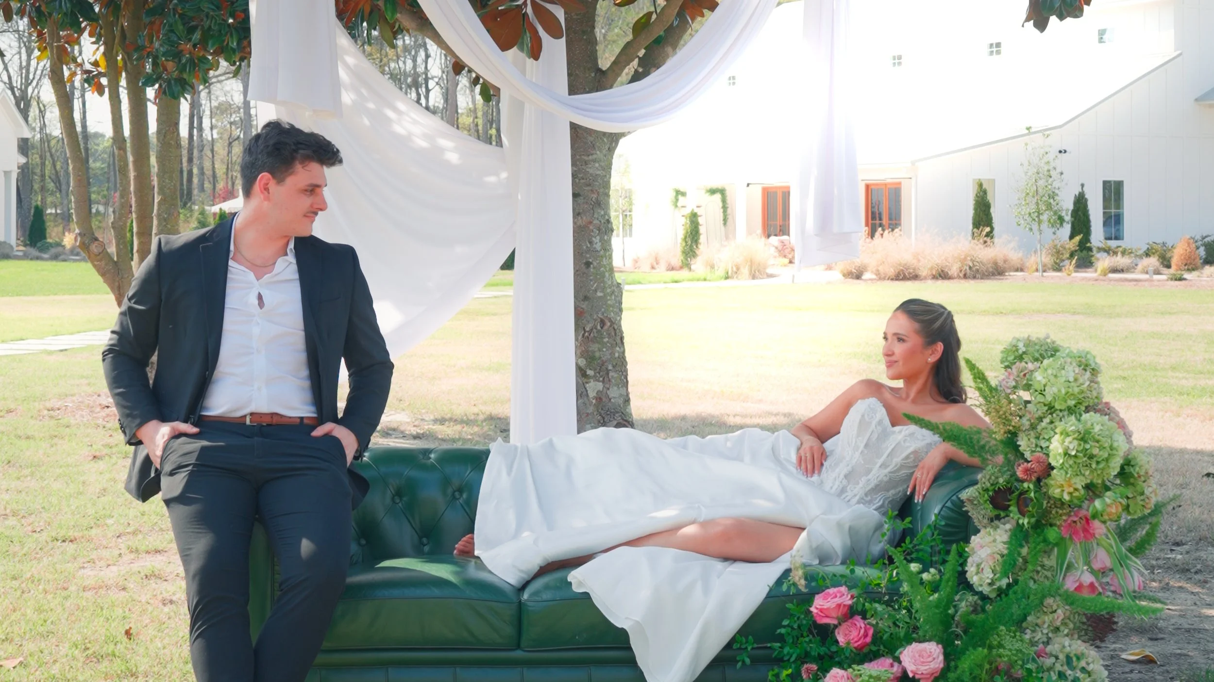 A happy bride and groom holding hands and walking through a sunflower field on a sunny day.