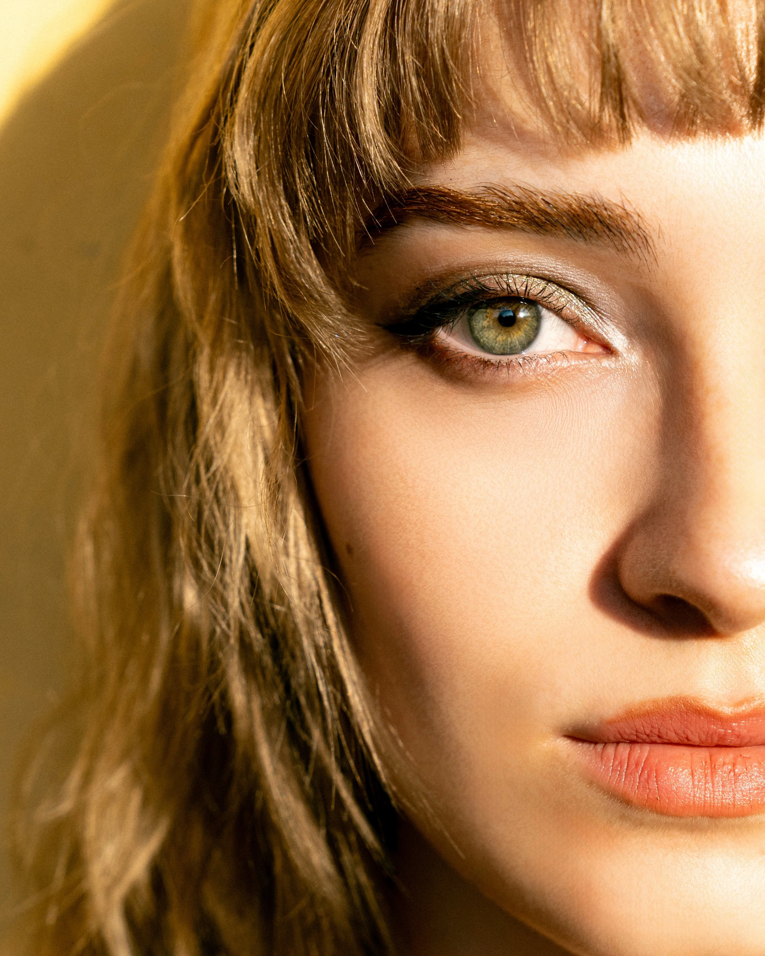 Close-up of a woman's face showing one eye, part of her lips, and hair.