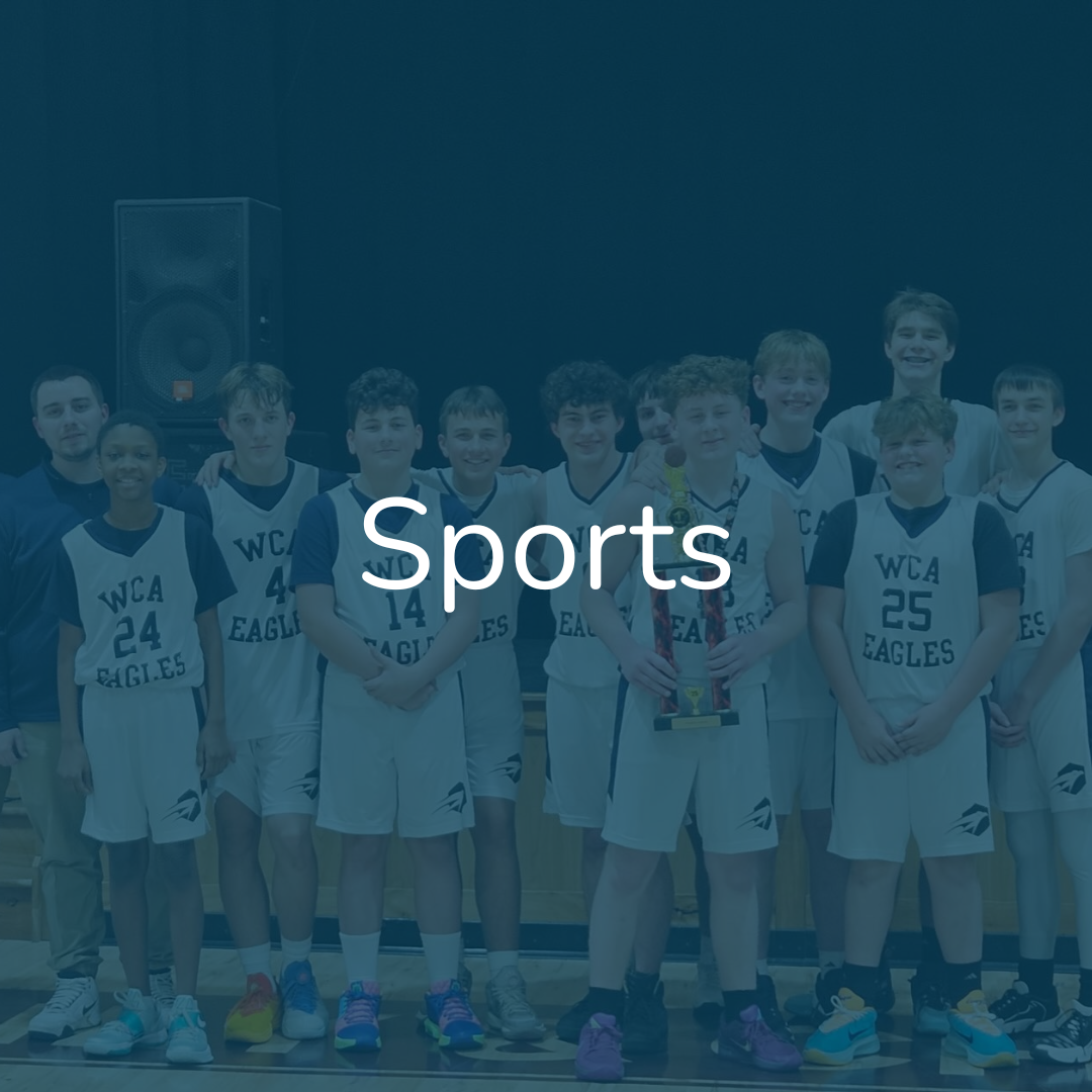 A youth basketball team in white and blue jerseys with 'WCA Eagles' printed on them, posing for a team photo after a game or tournament, with one player holding a trophy.