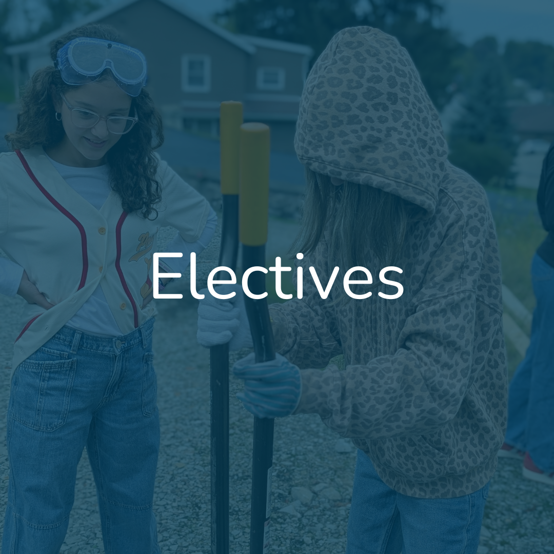 Two girls outdoors, one with curly hair and goggles on her head, smiling and wearing a baseball jersey, the other with a hooded animal print jacket, holding a shovel, during daytime.