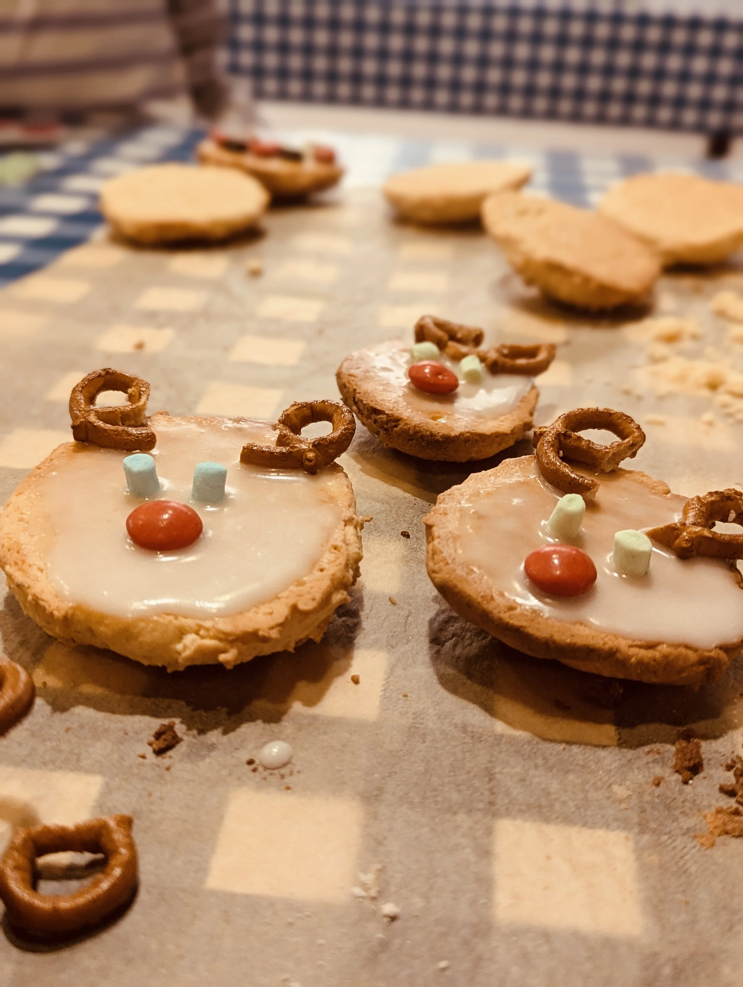Weihnachtlich verzierte Kekse mit Brezelgeweih und kleinen Süßigkeiten.