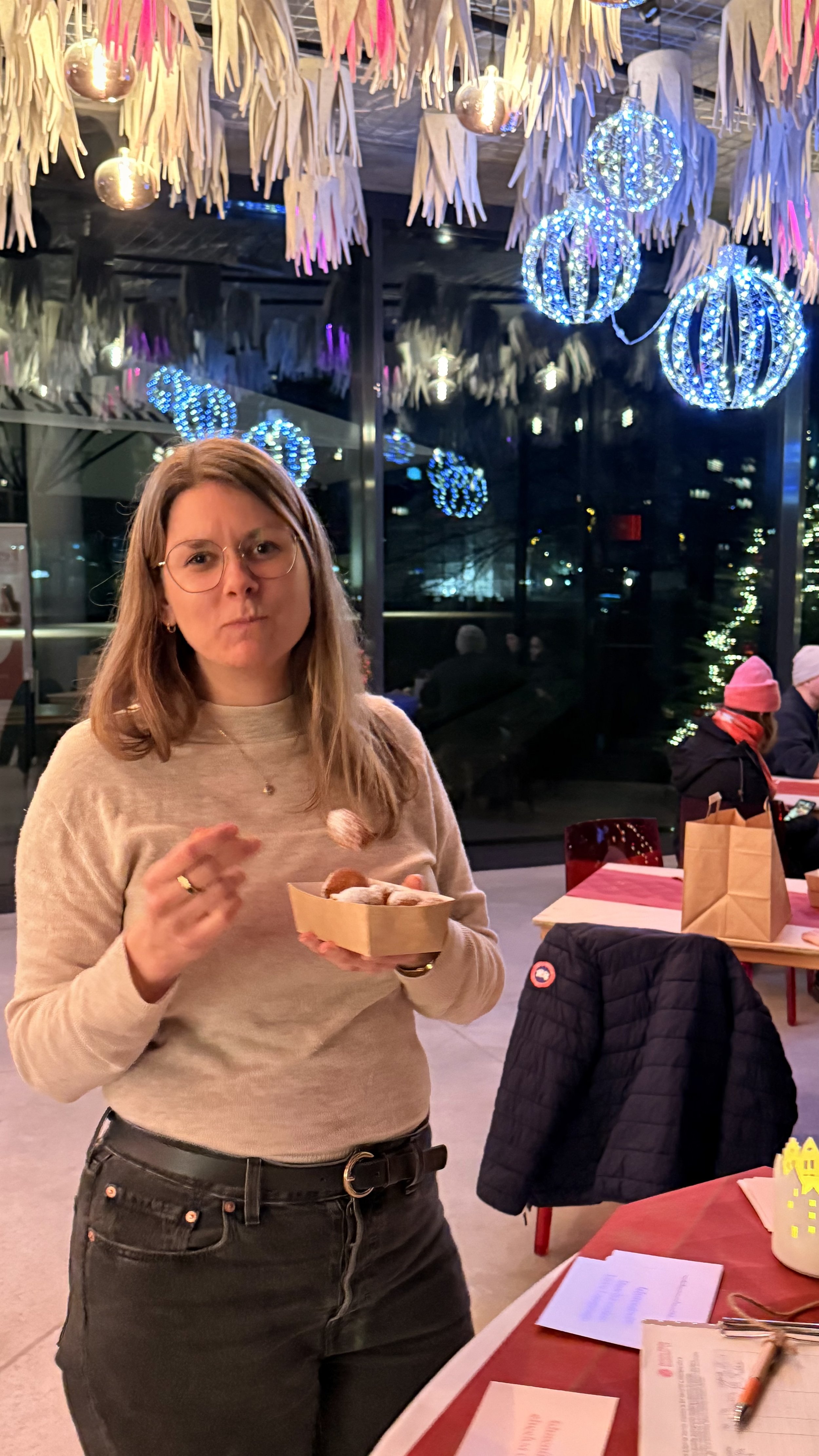 Eine Frau mit Zöliakie probiert bei einer weihnachtlichen Veranstaltung ein Gebäck von einem Pappteller.