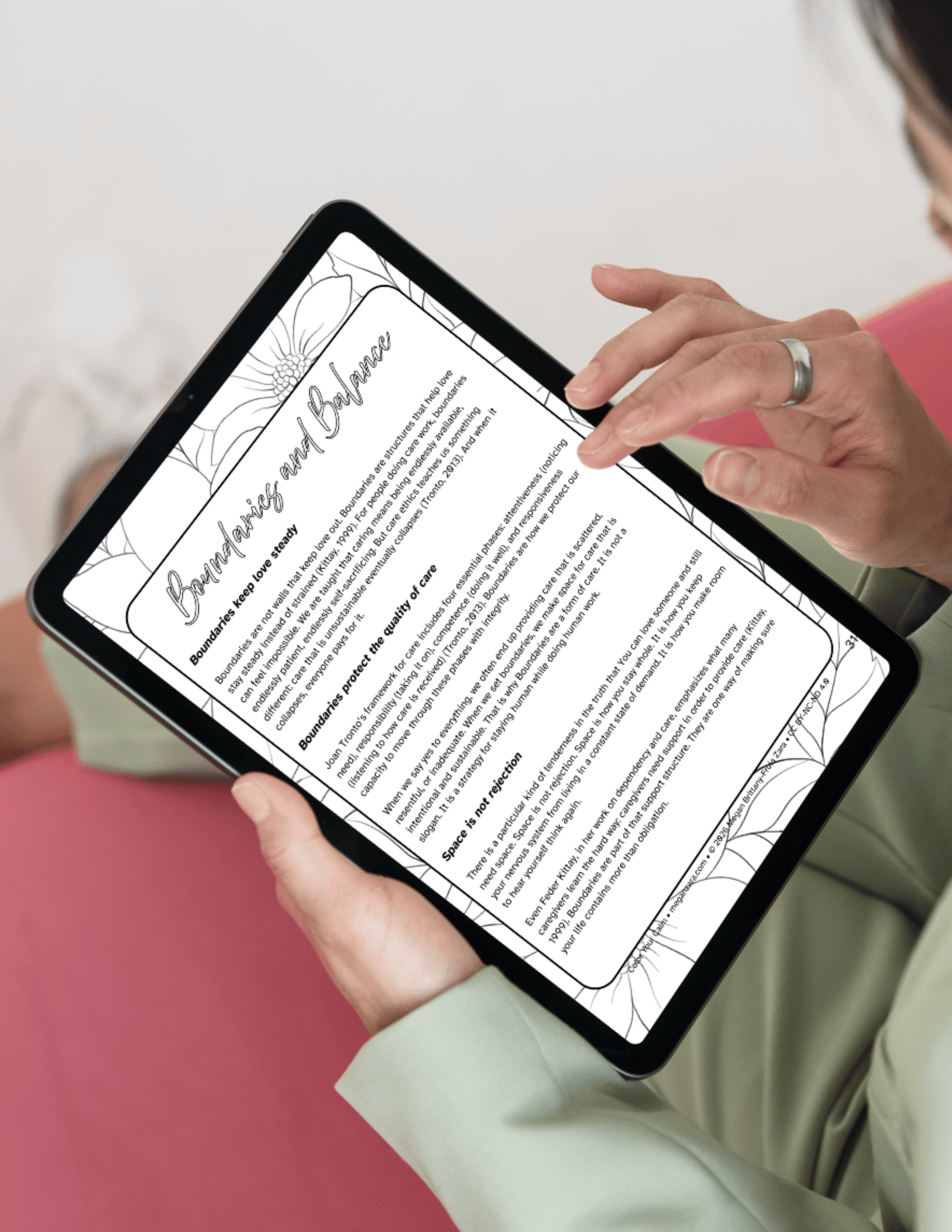 Person's hands holding a tablet displaying the 'Boundaries and Belonging' page from Color Your Calm, showing reflection prompts and practices with decorative floral line art borders.