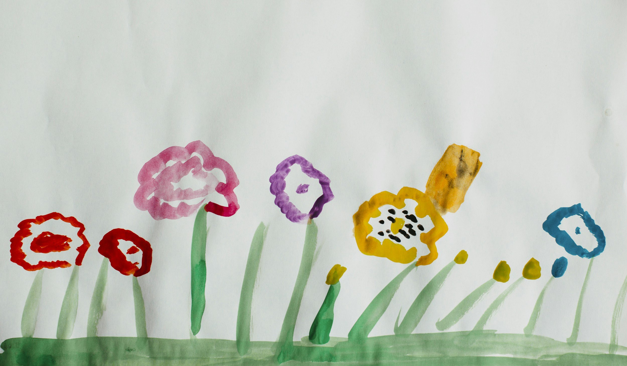 Colorful hand-painted flowers on white background, including red, pink, purple, yellow, and blue flowers with green stems and leaves.