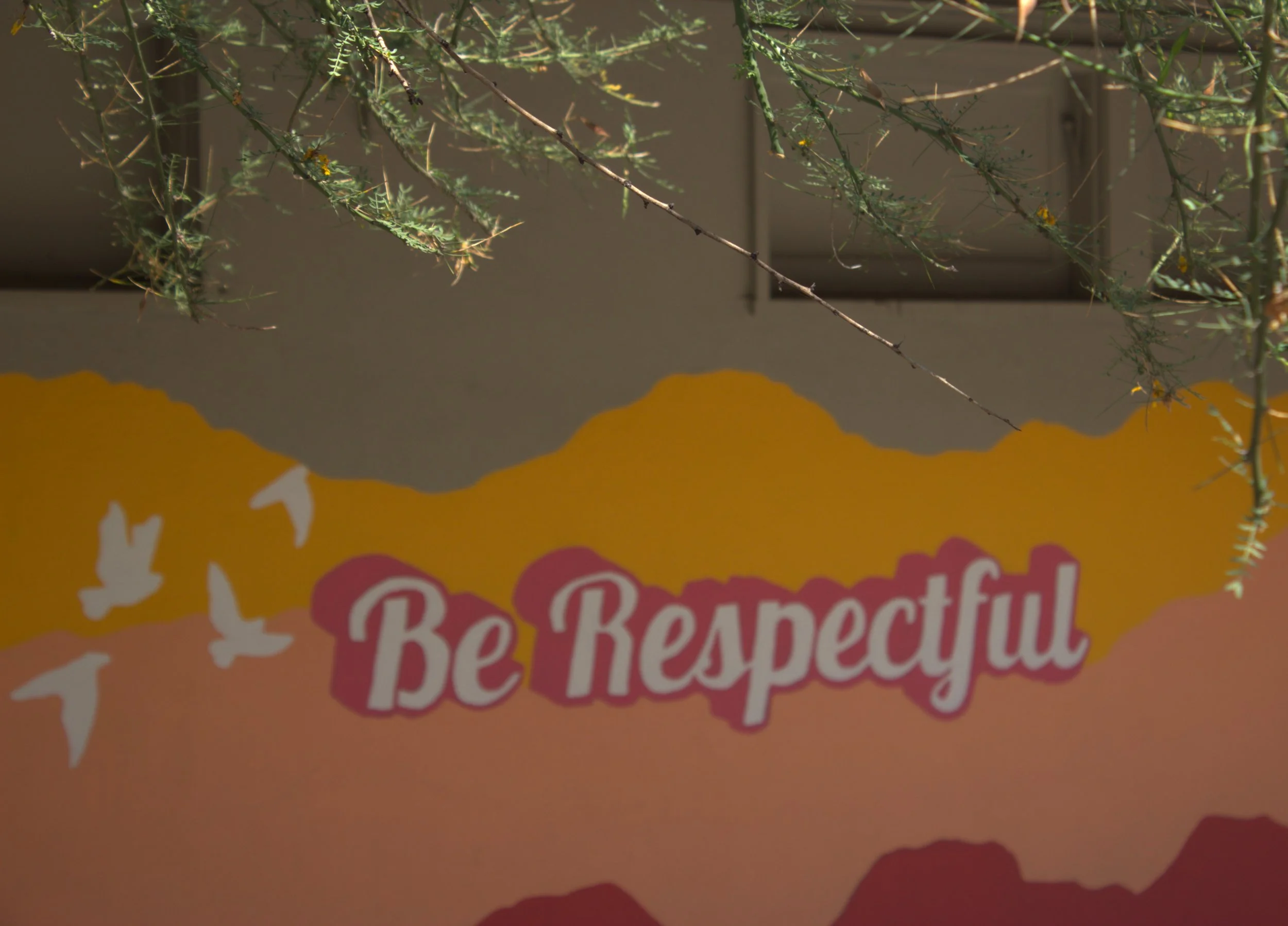 Colorful orange and red mural that reads "Be Respectful"
